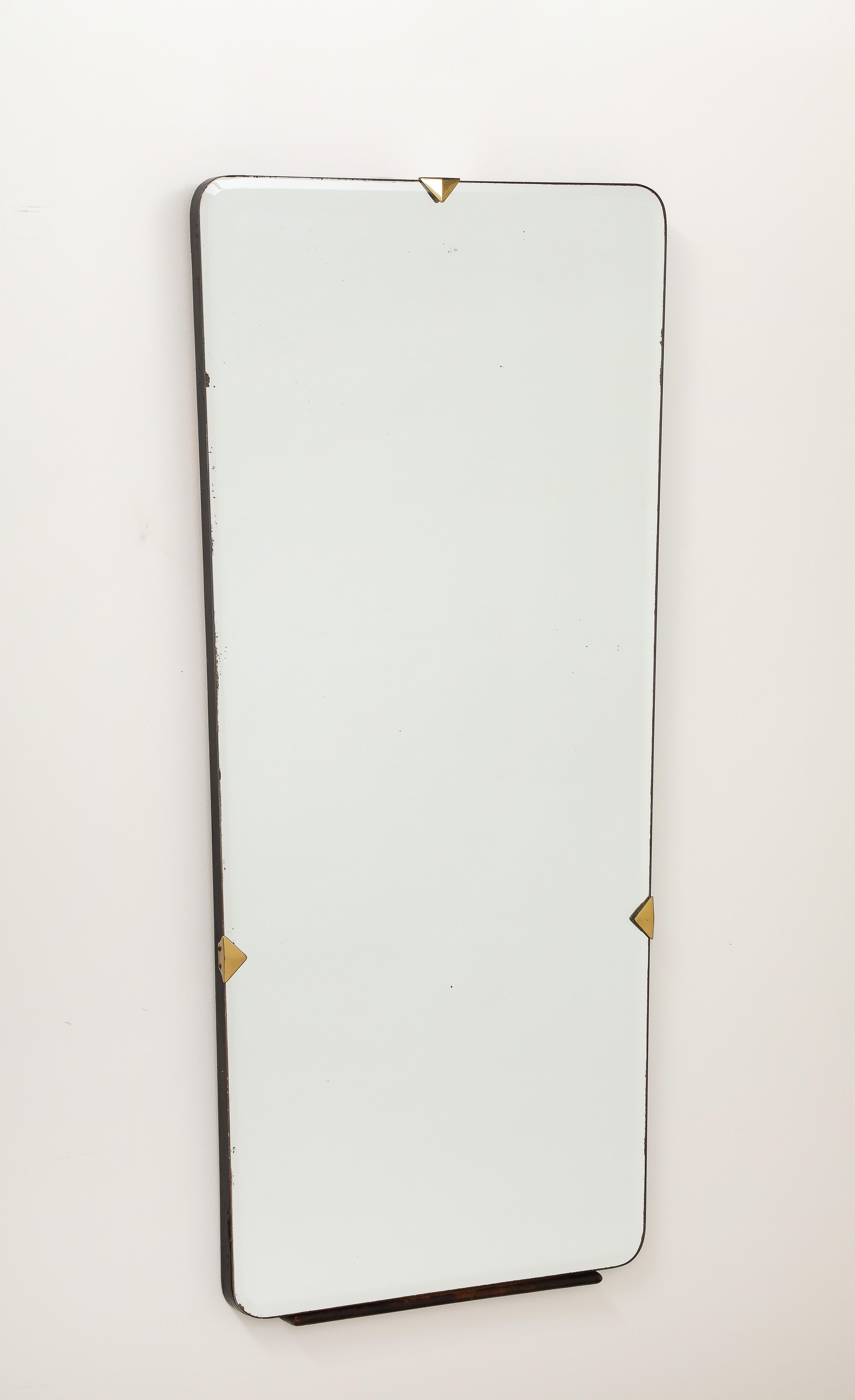 Italian 1940's shaped wall mirror with wood surround and base support, with brass triangular decorations on central top and on each side.  A simple and refined piece. 
Italy, circa 1940
Size: 45 3/4