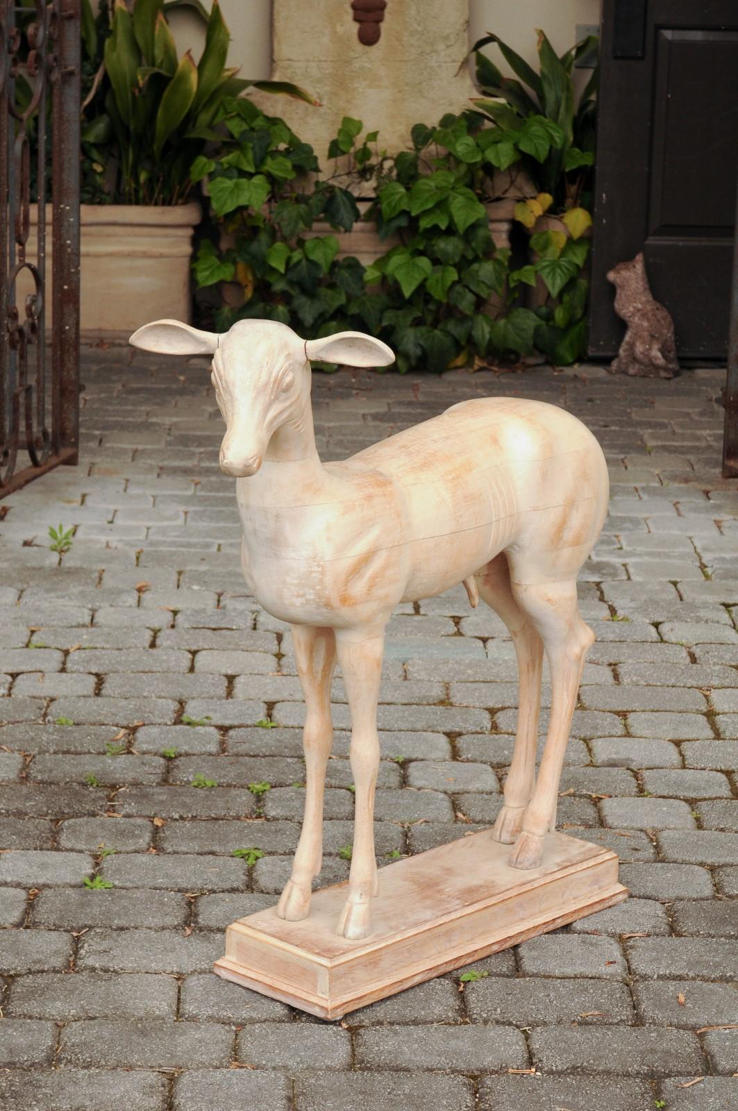 An Italian carved wood Pompeian style deer from the mid-20th century, with cream finish. Born in Italy during the second quarter of the 20th century, this Pompeian style carved deer found its inspiration in two bronze sculptures found in 1756 in the