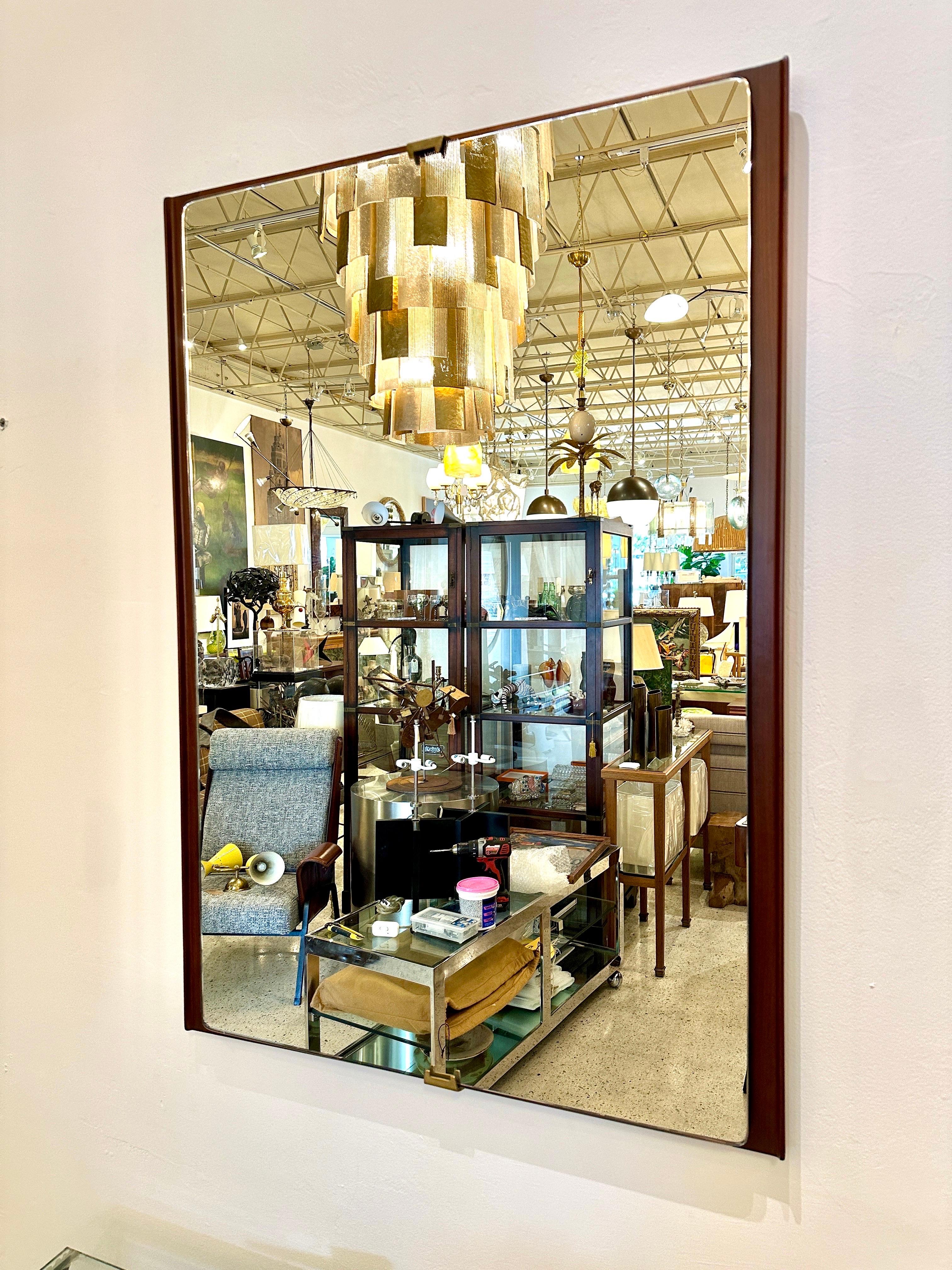 This is a fantastic 1940's era Italian Deco wall mirror with a floating mirror over wood frame, held by brass clips to top and bottom.  The walnut wood frame is rich and a beautiful natural color, the mirror is without damage - READY to hang! 