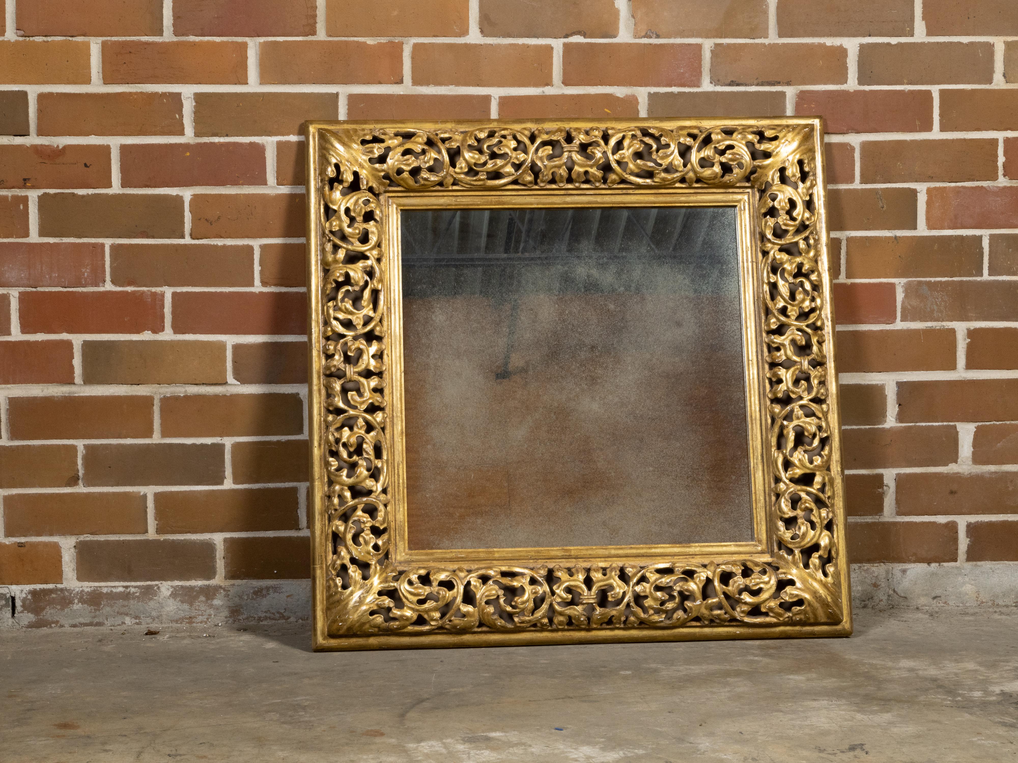 An Italian giltwood square-shaped mirror from the mid 20th century with openwork carved foliage and acanthus leaves corners. Created in Italy during the second quarter of the 20th century, this square-shaped mirror features an exquisite openwork