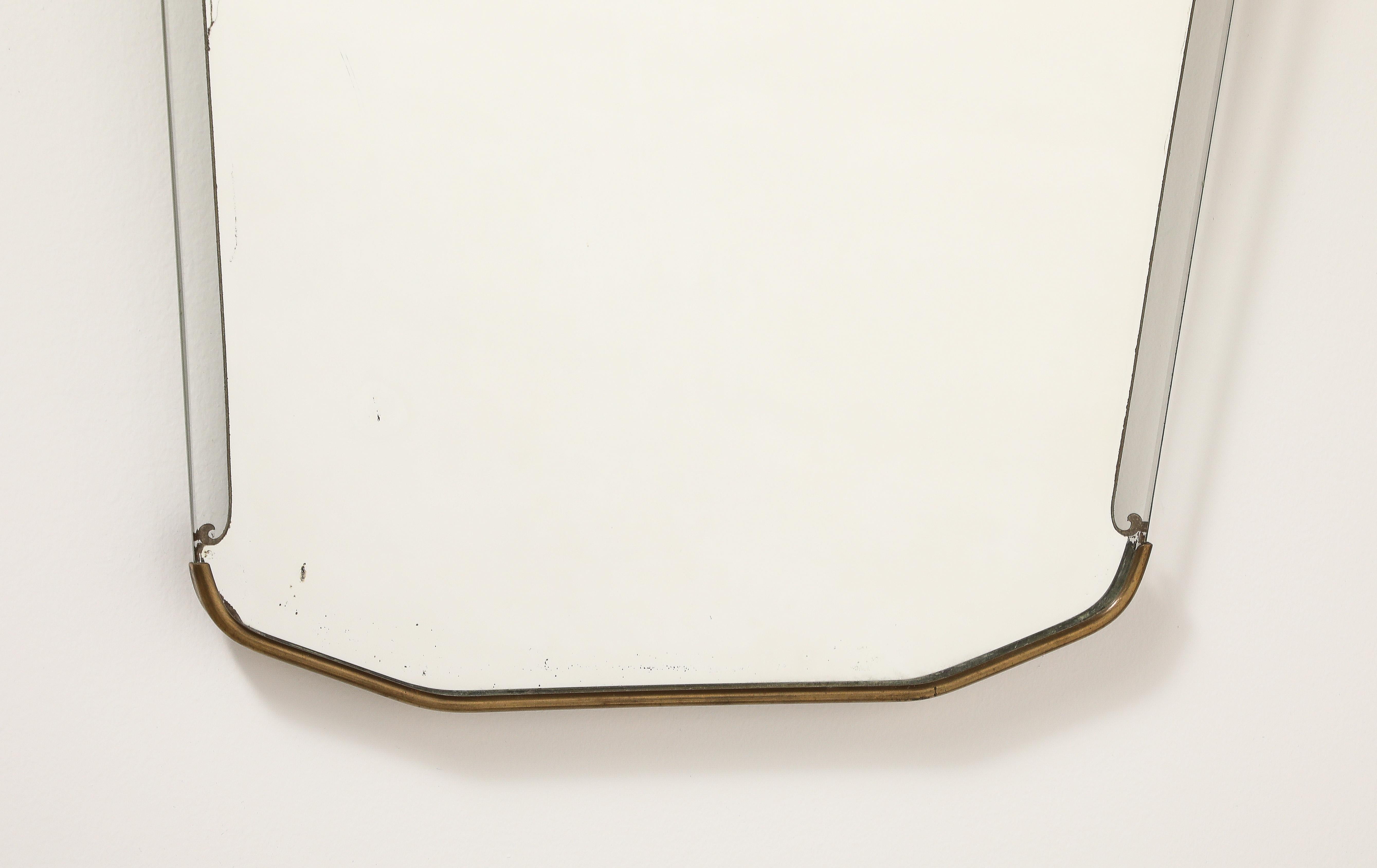 A very fine Italian Art Deco wall mirror, the shaped glass frame with brass molding on the base and brass scallop motif on the crest, with gilt trim on the outer clear glass frame. With wood back support. 
Italy, circa 1940 
Size: 23 3/4