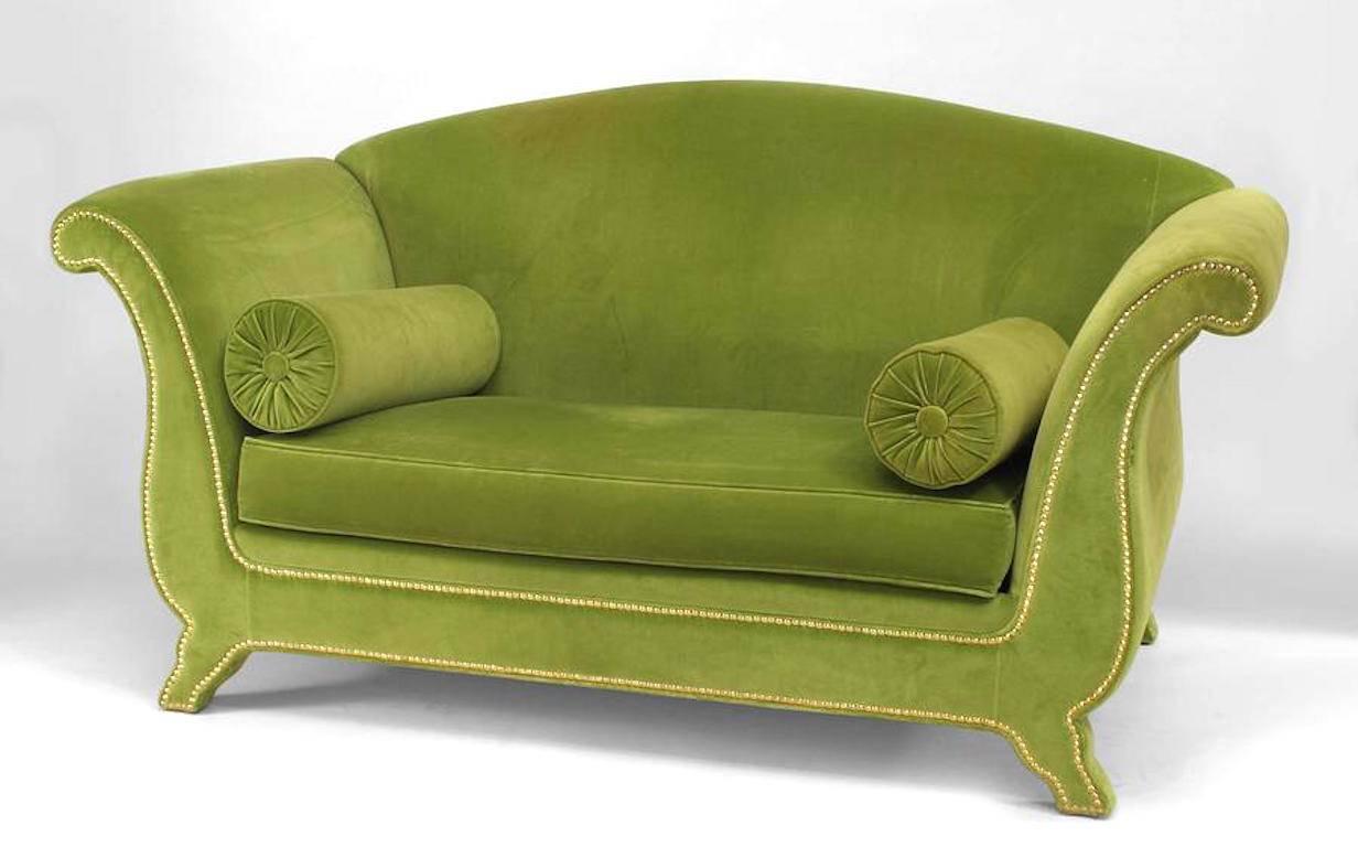 Italian 1940s style (modern) loveseat with camel back design and flaired arms upholstered in light green velvet with one large seat cushion, two bolsters, and brass nail head trim midcentury.
 