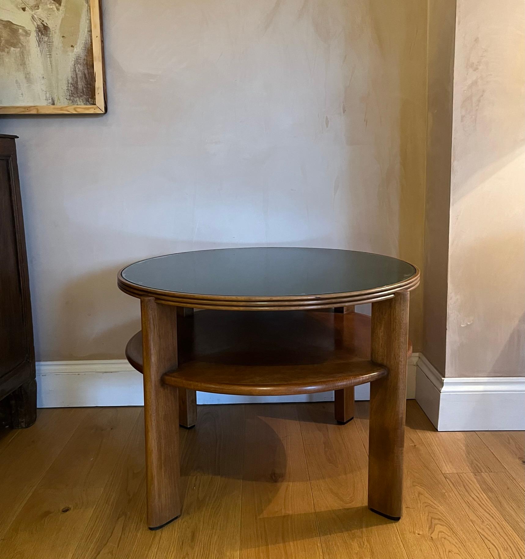 À superbe circular two tier mahogany table with original green glass top. Ebonised détail to the bottom of the legs. Original makers label to the underside. Designed by Enrico & Paolo Borghi.