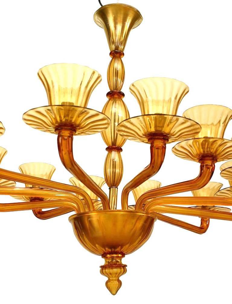 Italian 1940s Venetian Murano amber fluted glass oval shaped chandelier with 12 arms holding a flaired cup shade with a finial bottom and three section centre stem.
 