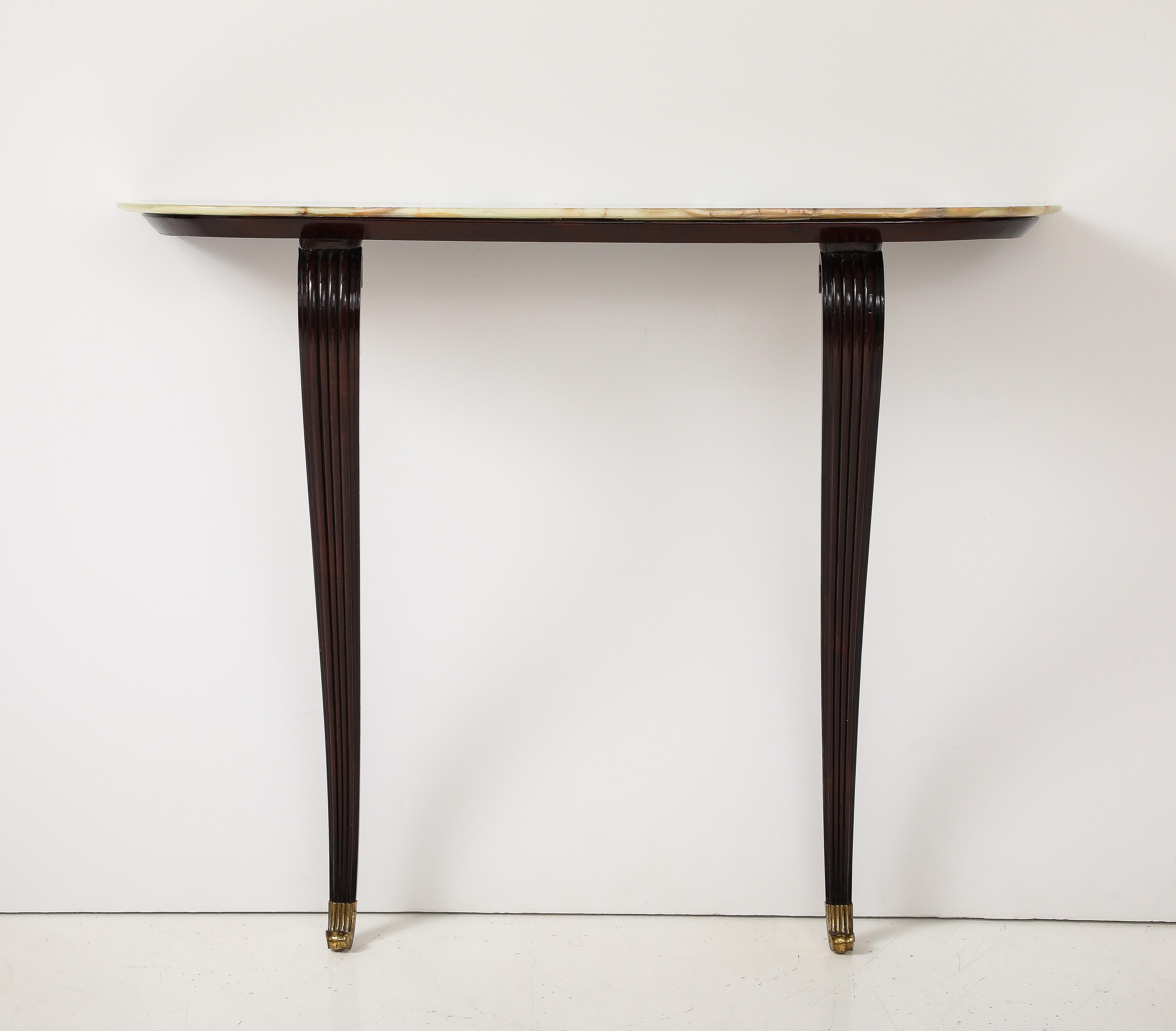 An Italian 1940's walnut wall-mount console table with cabriole fluted legs ending in brass scrolled sabot, supporting as stunning onyx top. Of very elegant proportions and a beautiful contrast of rich walnut with the natural onyx stone top.