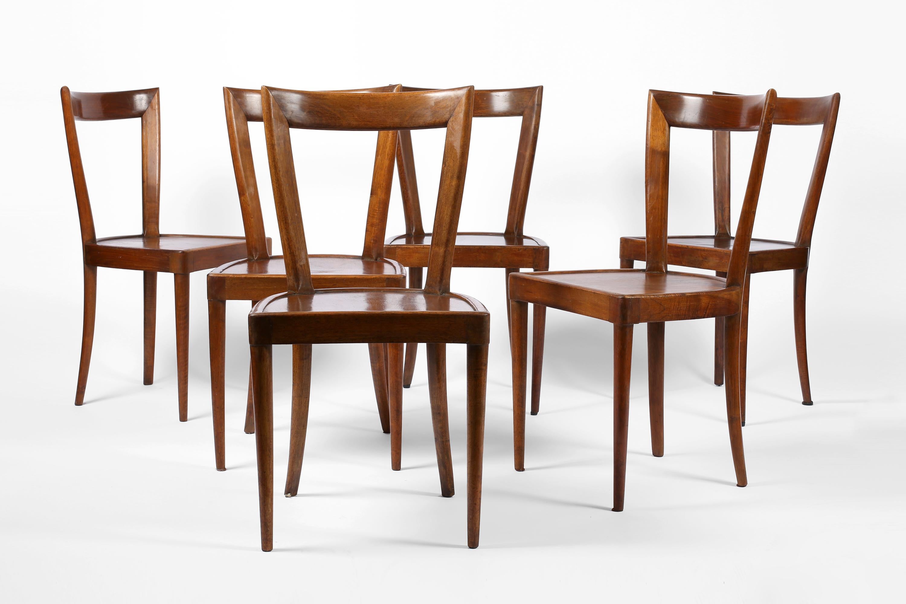 A set of six understatedly elegant dining chairs in walnut, manufactured by La Permanente Mobili Cantù - the factory that produced furniture by the likes of Gio Ponti & Paolo Buffa. Original paper manufacturer labels to the underside. Italian, c.