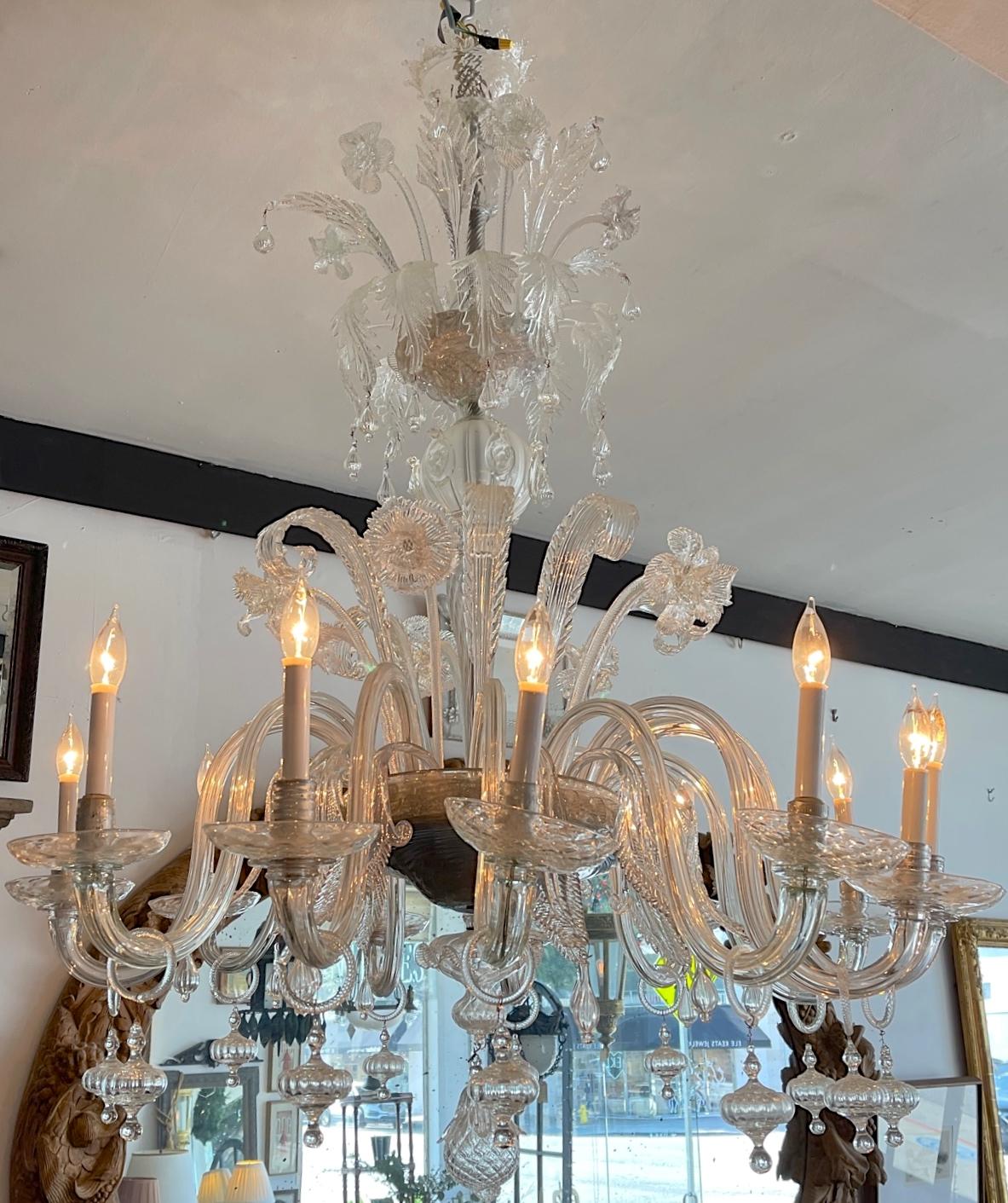 This is beautiful 12 arm 12 light Murano transparent glass chandelier. We have rewired it for use in the United States and we have added a small pleated shades for each light.