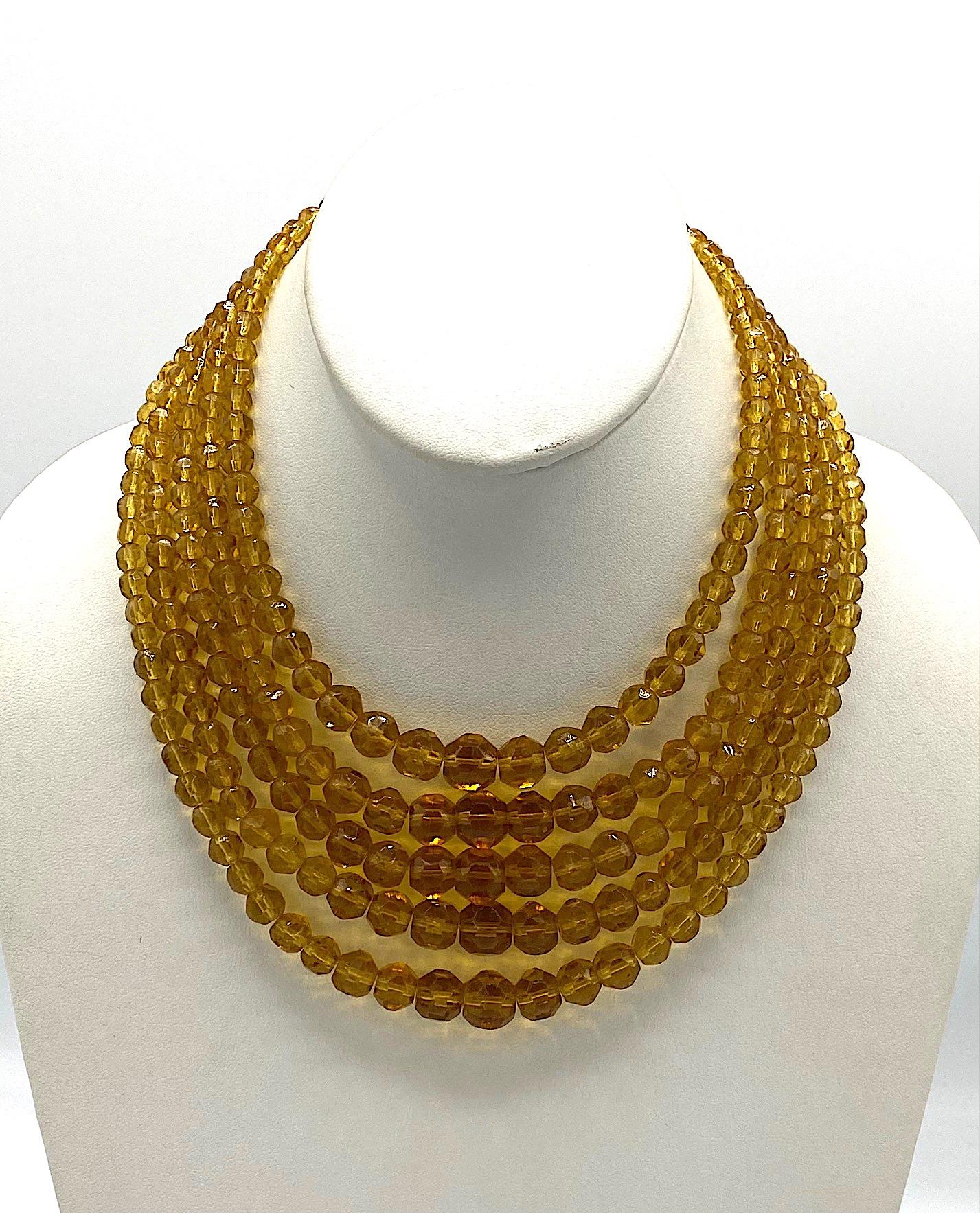 A lovely five strand graduated crystal bead bib necklace made in Italy and from the 1950s. Each of the five strands is comprised of golden light abler color beads from 5 mm to 10 mm in size. The necklace features a large oval push pin clasp 1.13