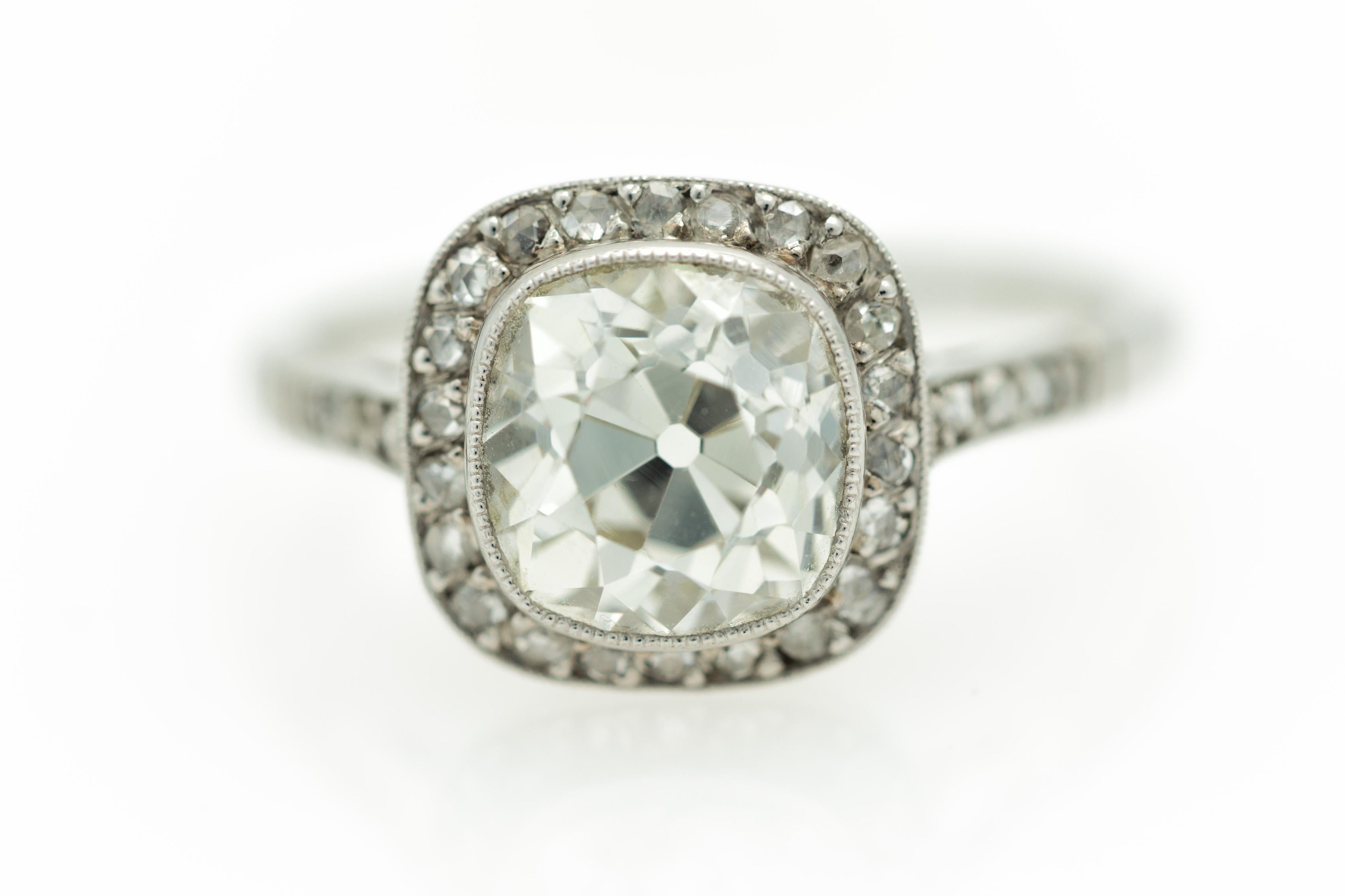 An Italian Art Deco Revival diamond halo engagement ring with a 2.64 carat solitaire Diamond in its center set in platinum size 7 ¼, circa 1950. Handmade in Italy during the midcentury period, this Art Deco halo ring features a 2.64 carat cushion