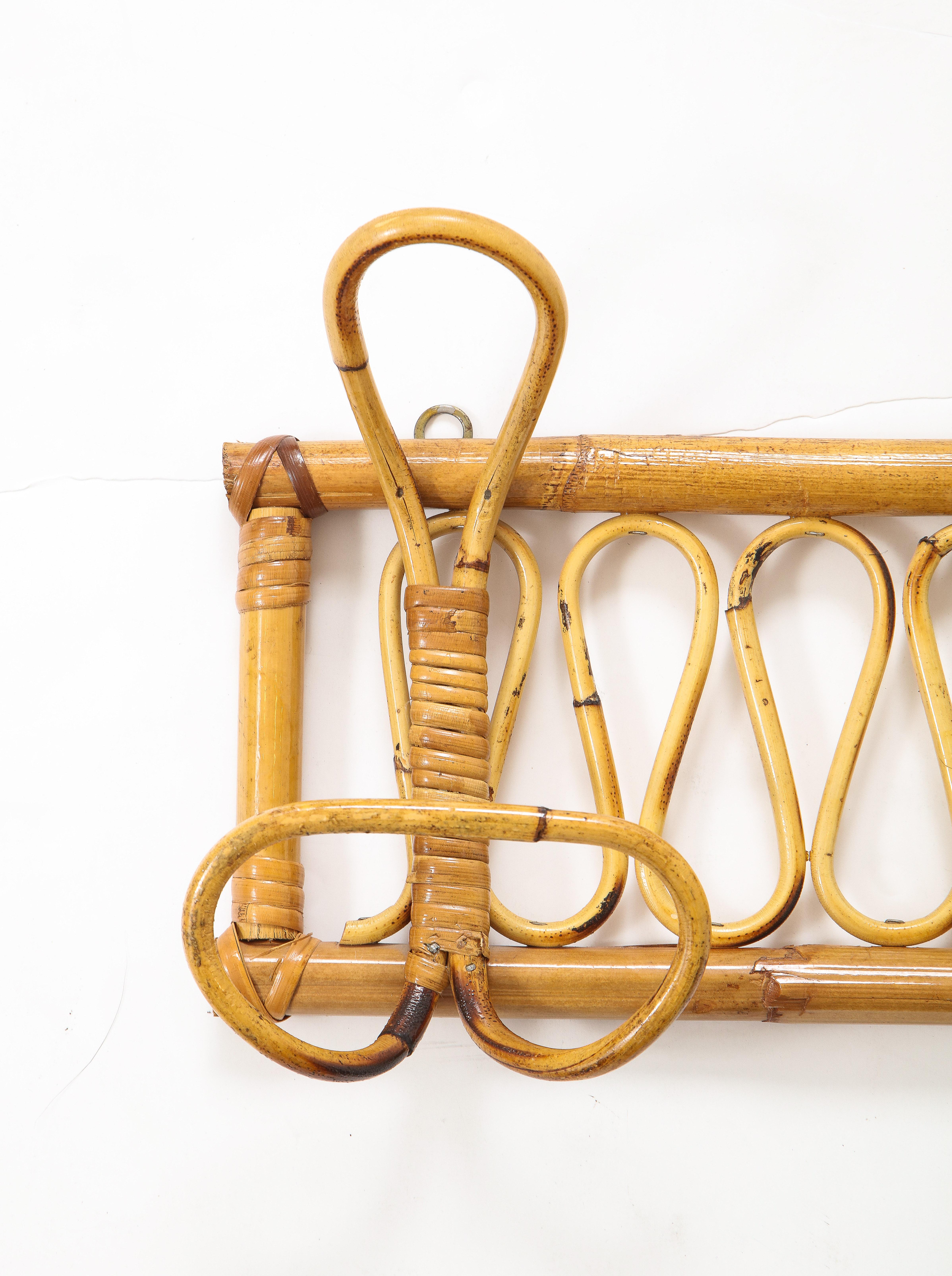 A charming Italian 1950's bamboo wall mounted coat or hat rack, with three ample hooks, ready to be hung and decorative scroll motifs throughout the rectangular frieze. An elegant and chic utilitarian addition to any foyer or mud room! 
Italy,