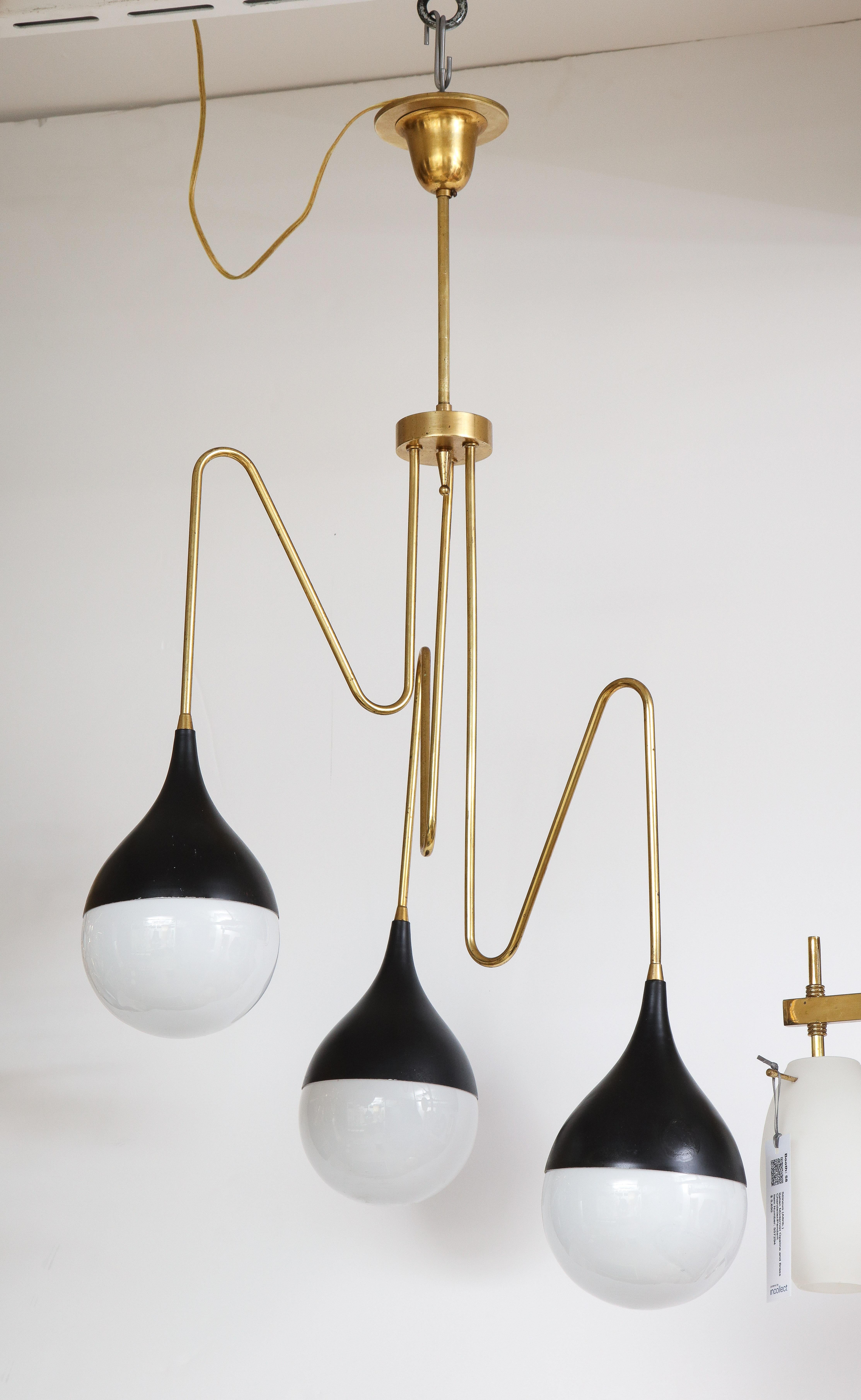 An Italian modernist chandelier with three opaline glass bulbs with black metal enclosures which extend from three angular brass shaped supports. Newly rewired for USA standards. A very striking and chic statement piece! 
Northern Italy, circa mid-