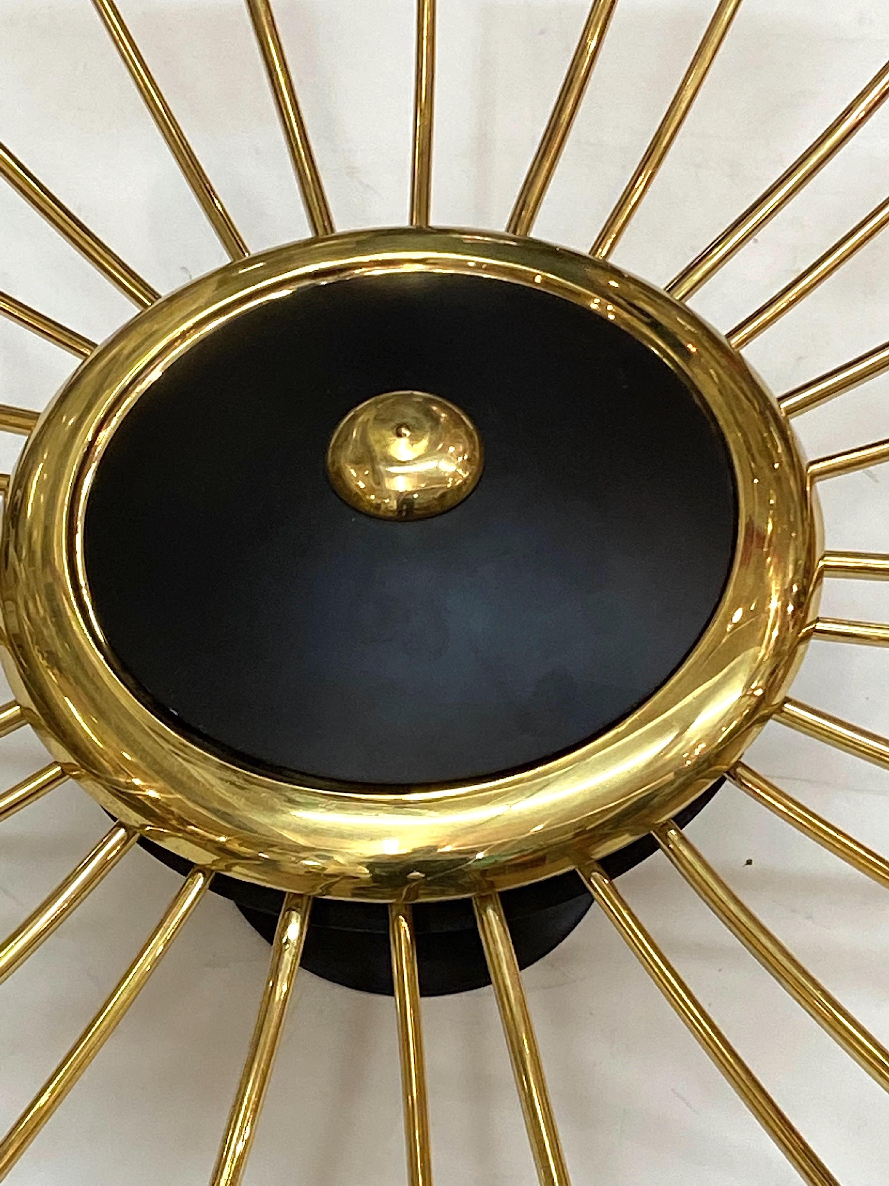 A spectacular and large 1950s Italian brass and black enamel light fixture in a star-burst design. The light measures 34 inches in diameter and is a direct to ceiling mount. There is a main central dish from which 14 alternating decorative brass