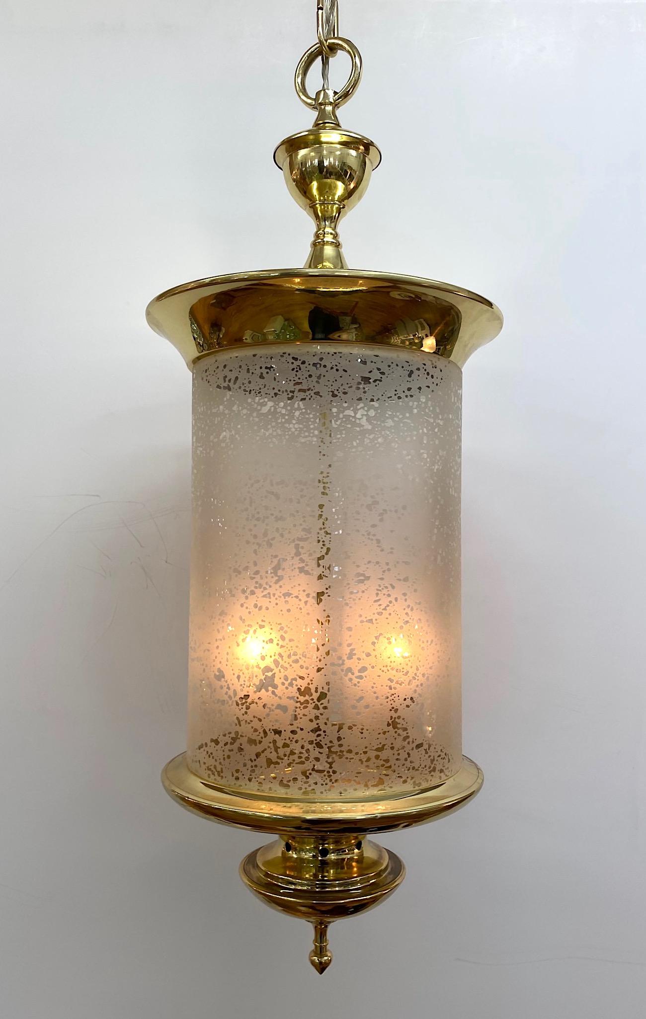 Une élégante lanterne italienne en laiton de conception classique, vers 1950. Le laiton est nouvellement poli et laqué. L'abat-jour en verre soufflé à la main est gravé à l'acide avec un motif chiné clair et givré pour adoucir la lumière. Chaîne