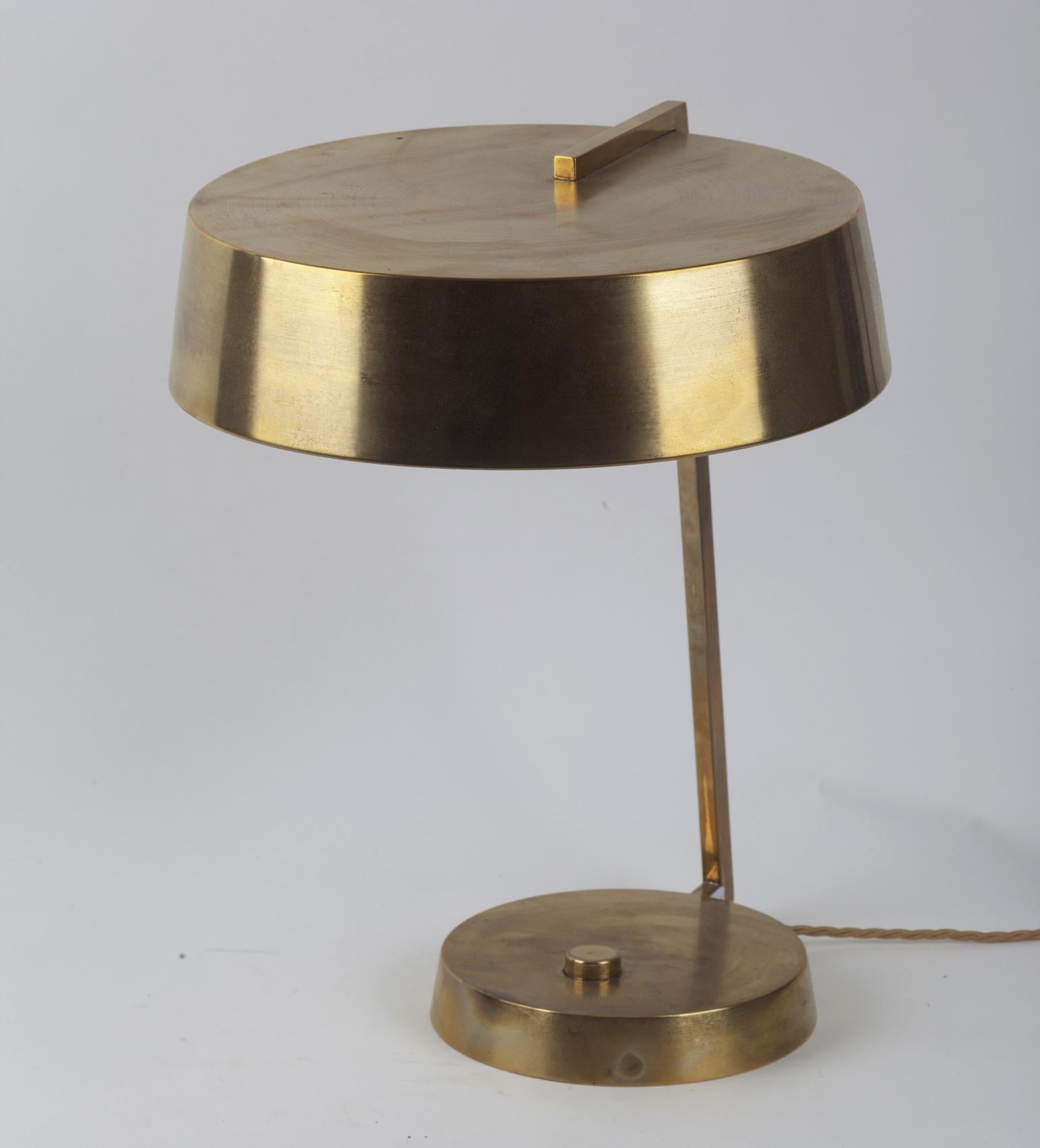 Italian 1950s table or desk lamp by Stilux, Milano. It has a round brass shade supported by a brass arm and round brass base.
