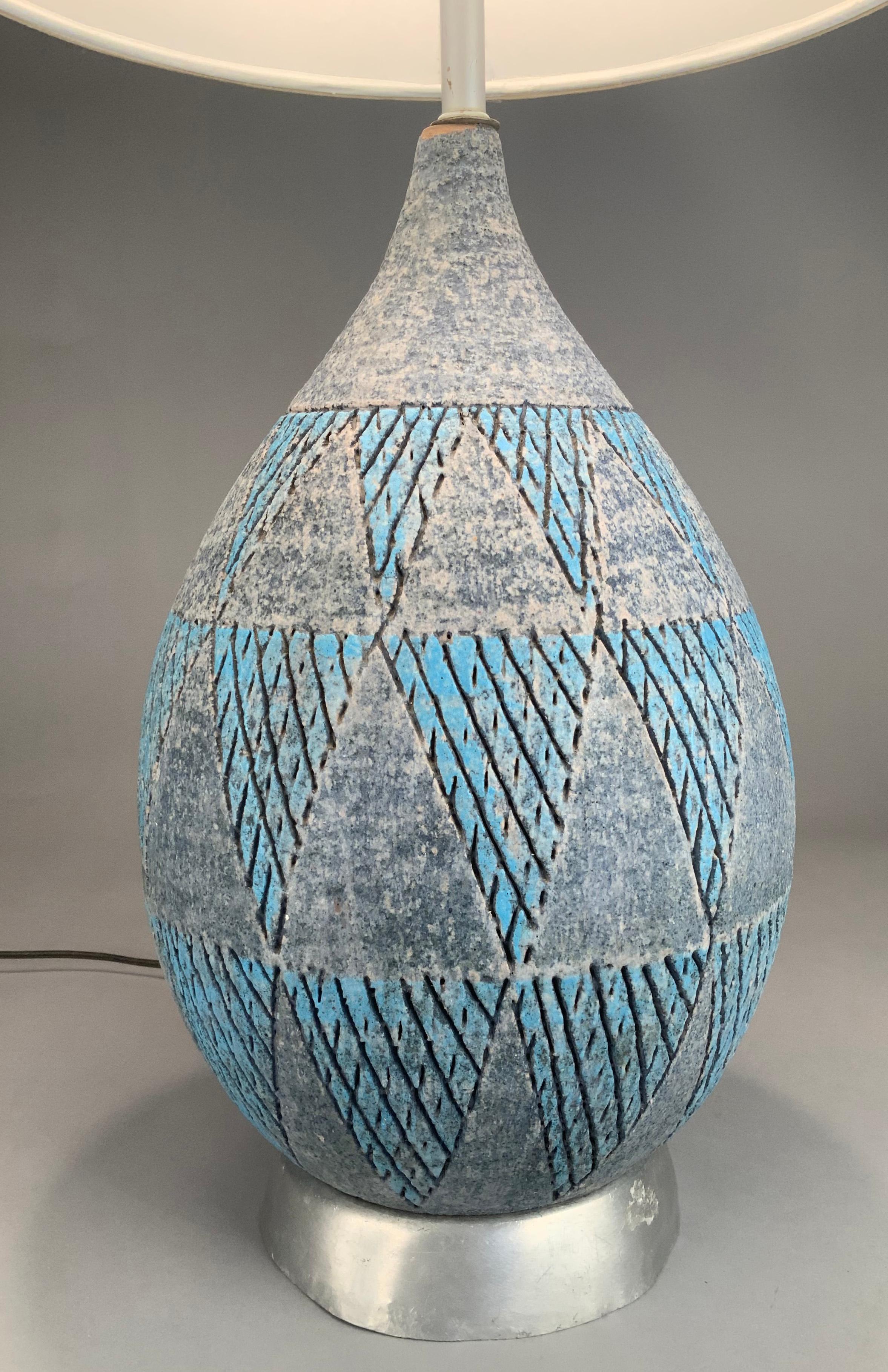 A beautiful vintage 1950's Italian glazed ceramic lamp by Bitossi. in a subtle gourd shape with a large base and tapered neck, the lamp is incised with a repeating triangle pattern, with cross hatching, and glazed in shades of blue and grey. Marked