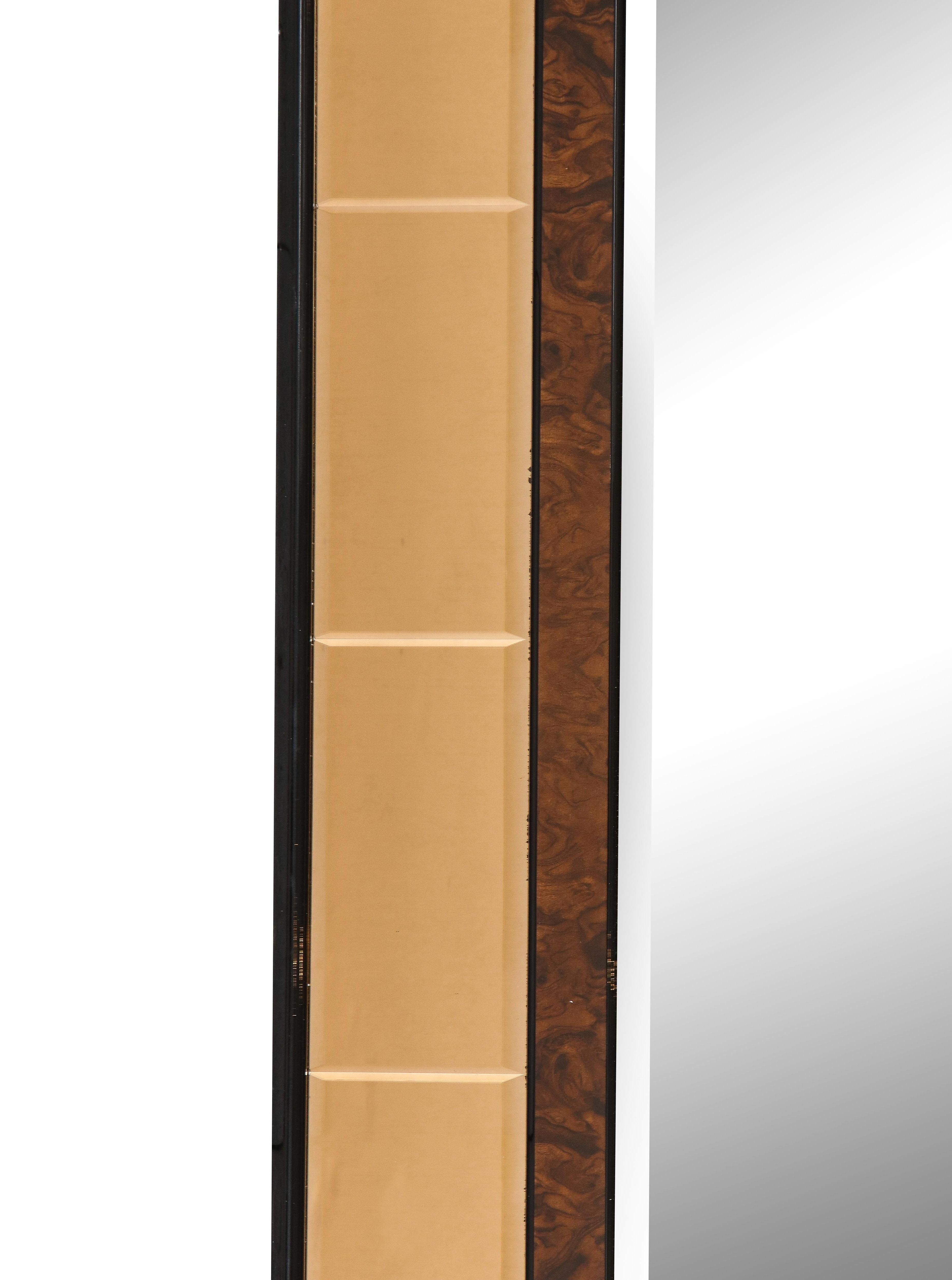 A monumentally sized Cristal Arte mirror with segmented beveled glass in a stunning amber/rose gold with an inner surround of burl wood which borders the inner clear glass, mounted on a wood back. The contrast of the burl wood and amber/rose gold