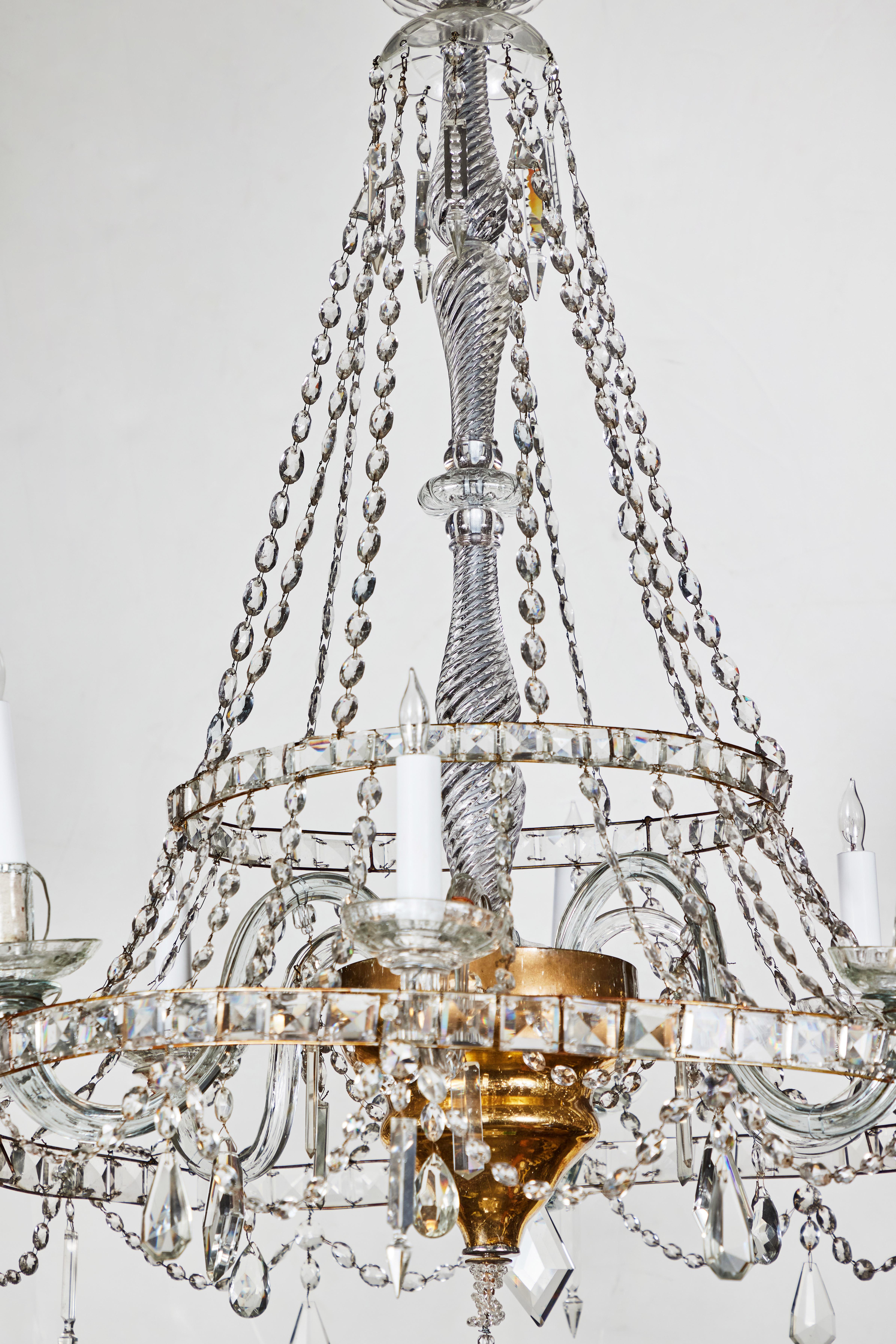 Graceful, six arm, crystal chandelier with a turned central column terminating in a gilt brass bucket with a large, crystal sphere below. Two levels are surrounded by hand-strung, crystal circlets. Wired for U.S. current.