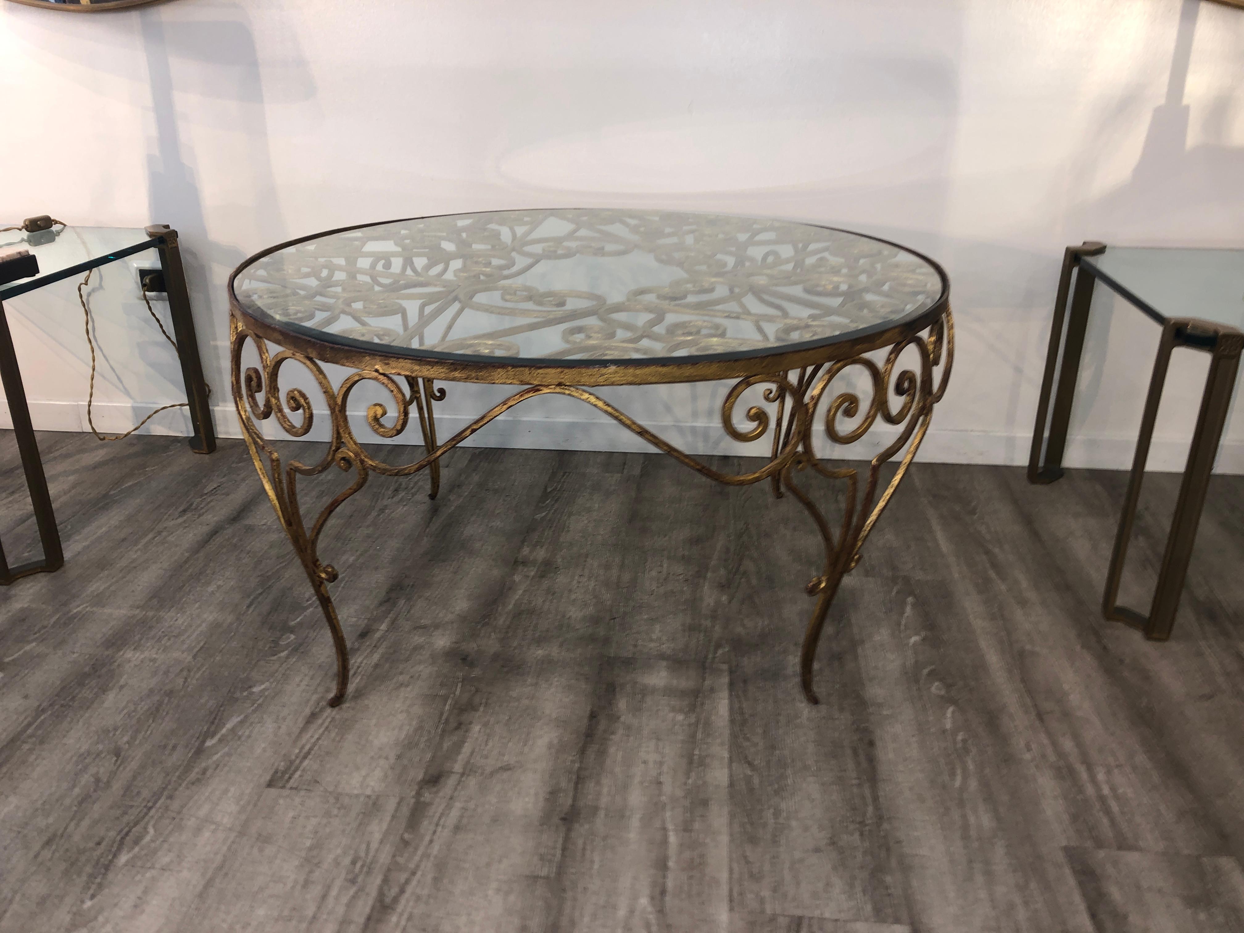 Italian 1950s decorative rounded golden wrought iron crystal top coffee table.
The crystal has a beveled edge and this is recently added.
No further restoration needed.

  