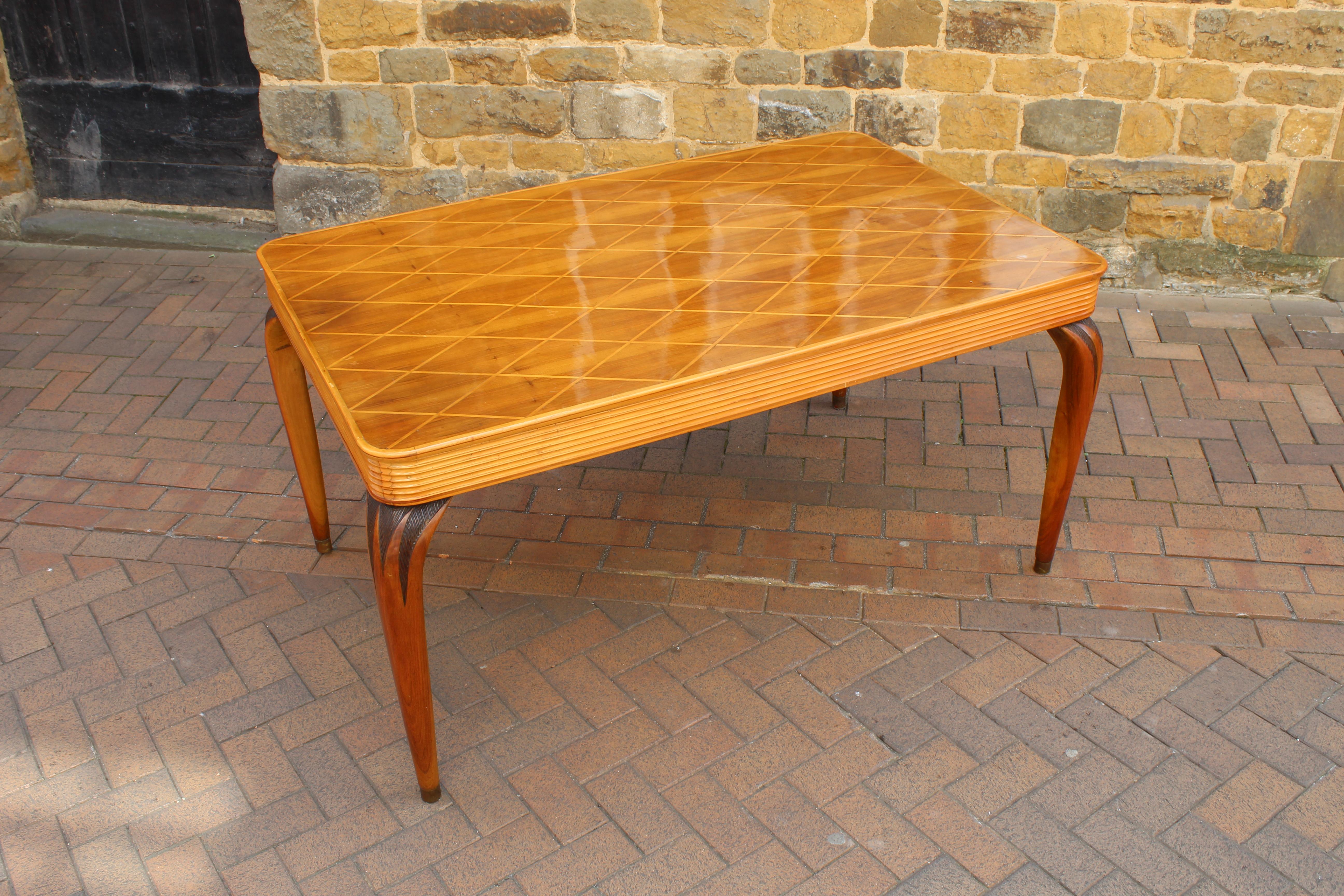 This is a superb 1950s Italian dining table by Paolo Buffa.

Very beautiful, rare and stylish table with inlaid details on the top, carved details on the legs and brass capped feet. 

 
