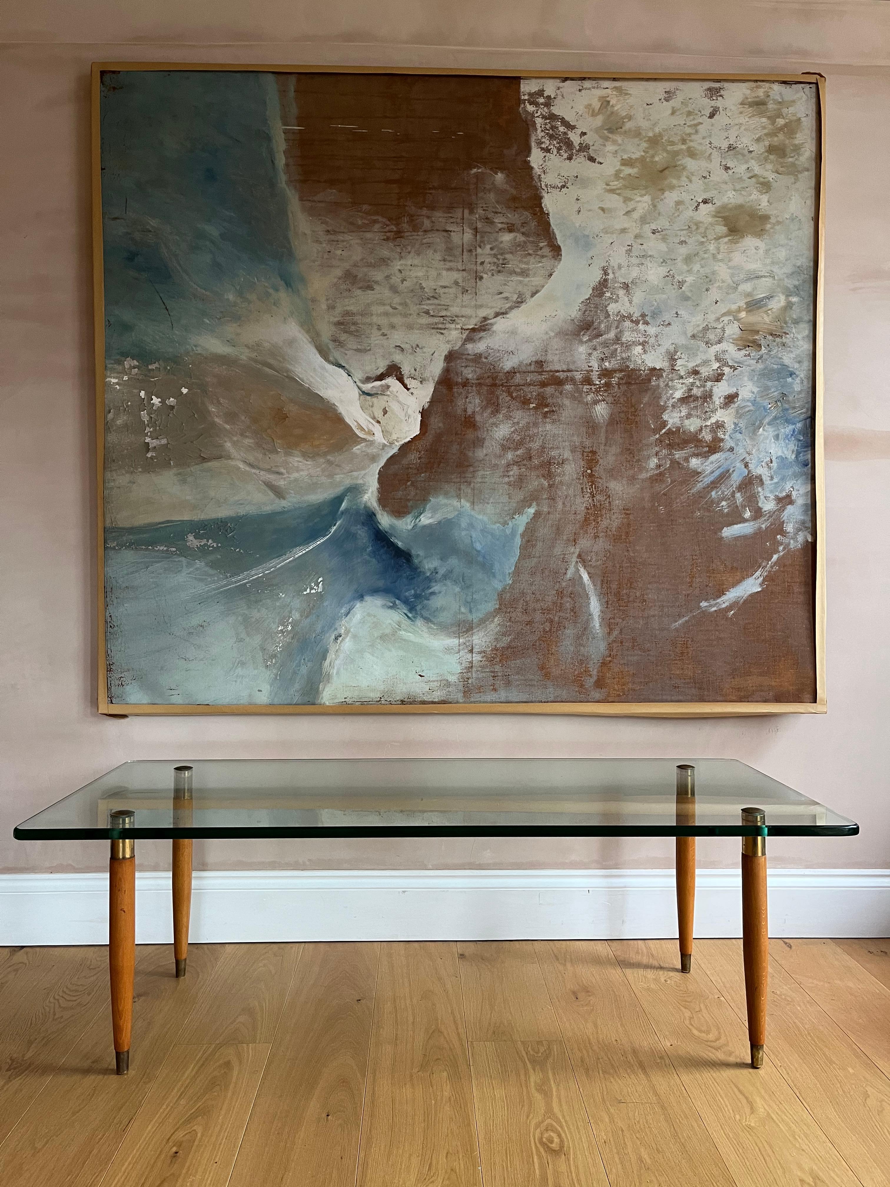 An elegant Fontana Arte glass, wood and gilt metal coffee table. The legs have been repolished. Glass is original and in good condition except for one small ding, which we have photographed though difficult to see. There are minor surface scratches