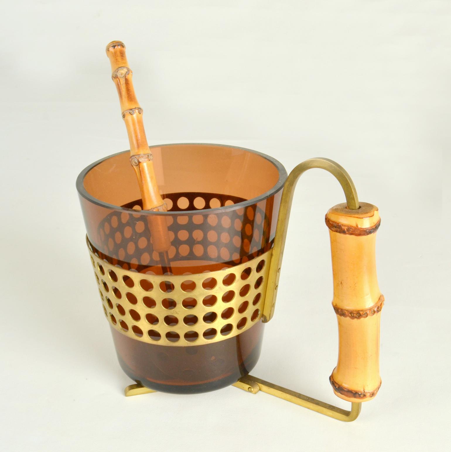 Elegant ice bucket for barware in Murano blown glass, brass and bamboo with matching spoon in brass with bamboo handle.
Dimensions Spoon; 21 x 5.5 x 3 cm.
Dimensions Glass container; D 12 x H 12 cm.