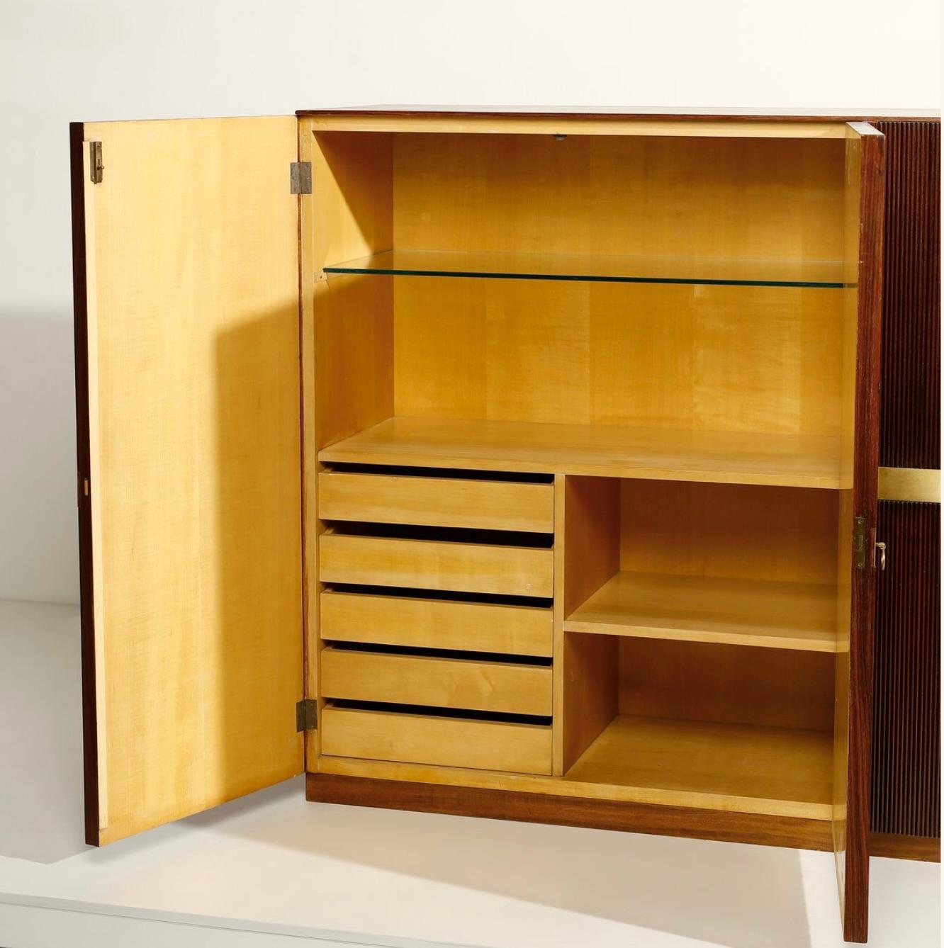 Grand meuble de salon italien attribué à Osvaldo Borsani, vers 1950. Les quatre portes ont une finition nervurée verticale avec des détails en laiton, des tiroirs intérieurs et des étagères en verre. 