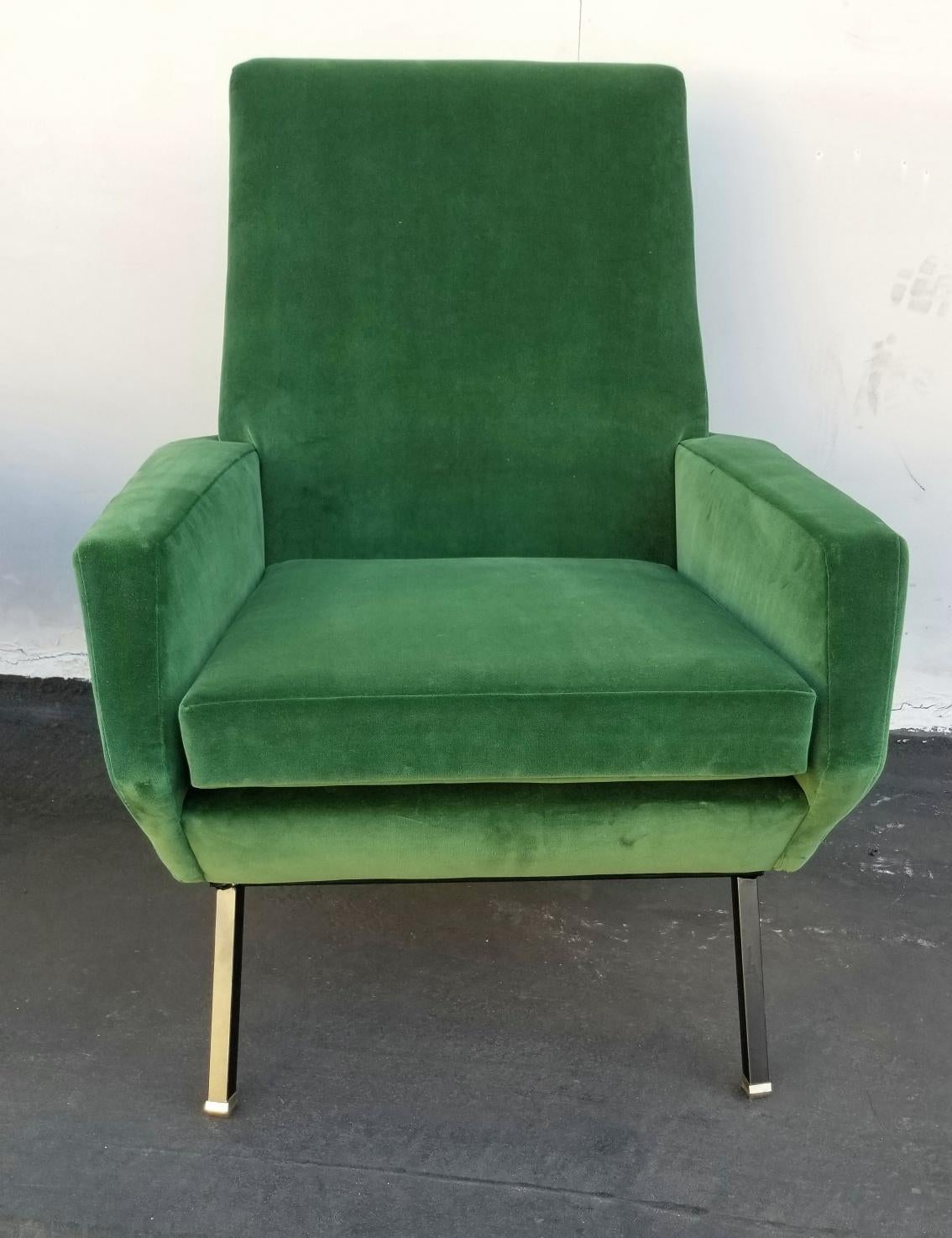 1950s pair of club chairs green velvet upholstery metal legs and brass boots.
  