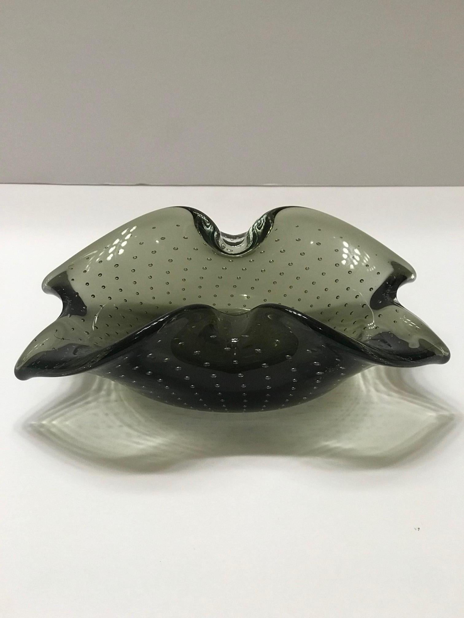 Mid-Century Modern hand blown Murano bowl in smoked grey glass with controlled bubbles. Organic form has floral inspired design also reminiscent of a butterfly. Can function as an ashtray or decorative bowl and is beautiful from all angles.