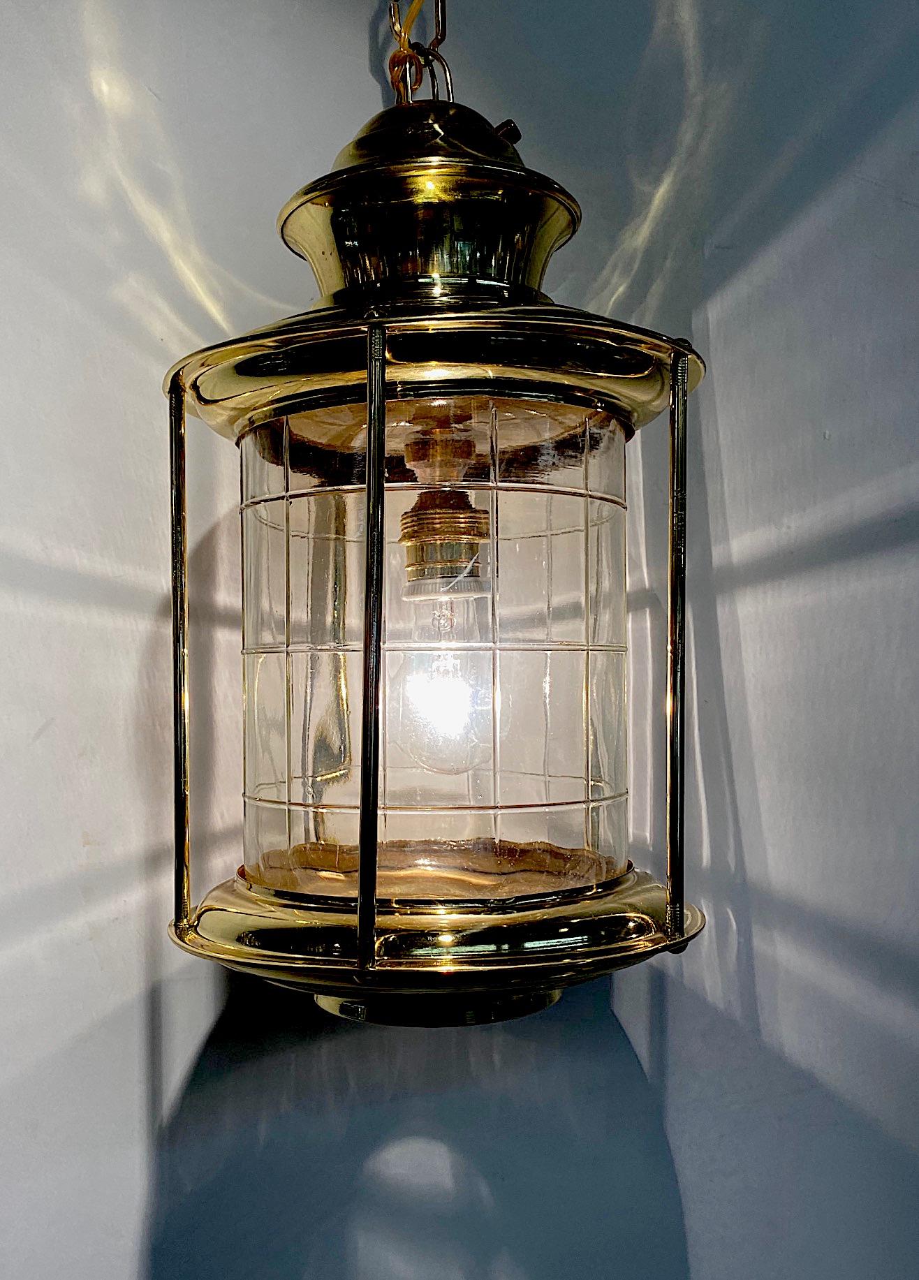 An Italian nautical style round pendant lantern in brass and blown glass circa 1950. The body of the lantern is 9 inches in diameter and 17 inches tall. Original brass decorative link chain is an 38 inches. The interior of the lantern has a blown