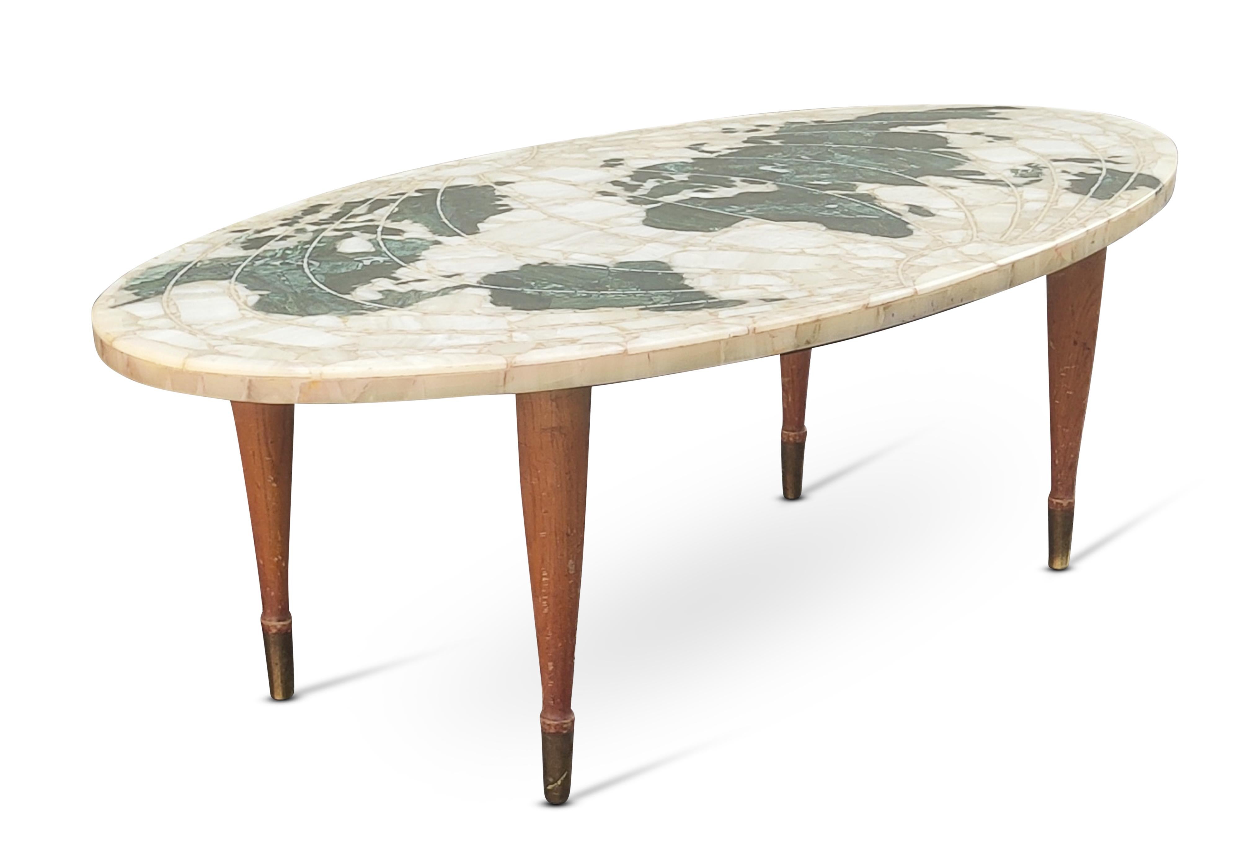 In the famous style of Ico Parisi, this authentic Italian MCM 1950s table is absolutely beautiful! Its oval marble top is intricately and painstakingly inlaid with hundreds of small marble & onyx pieces, in various shades of deep green and light