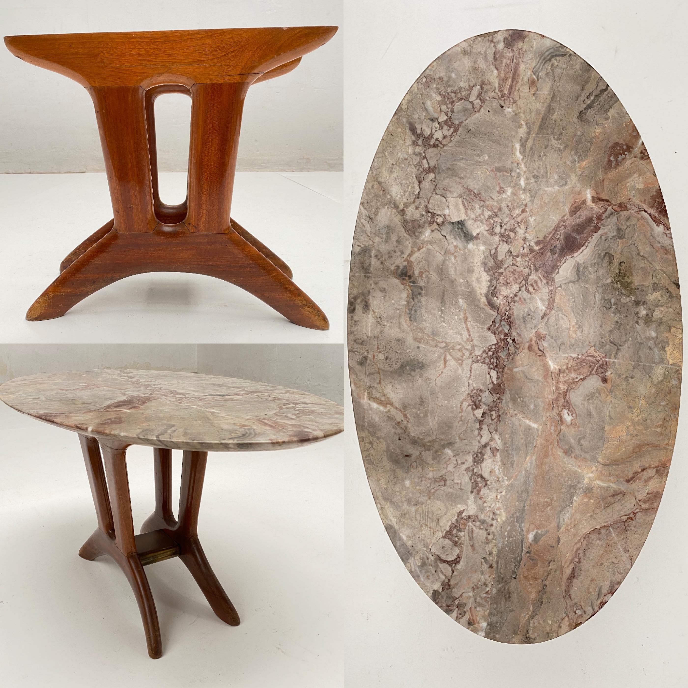 Cute Italian 1950s side table with a marble oval top in the style of Ico Parisi 

The base is made of solid carved walnut and its shape has nice organic details and a wonderful aging patina 

A brass detail finishes of this wonderful base
