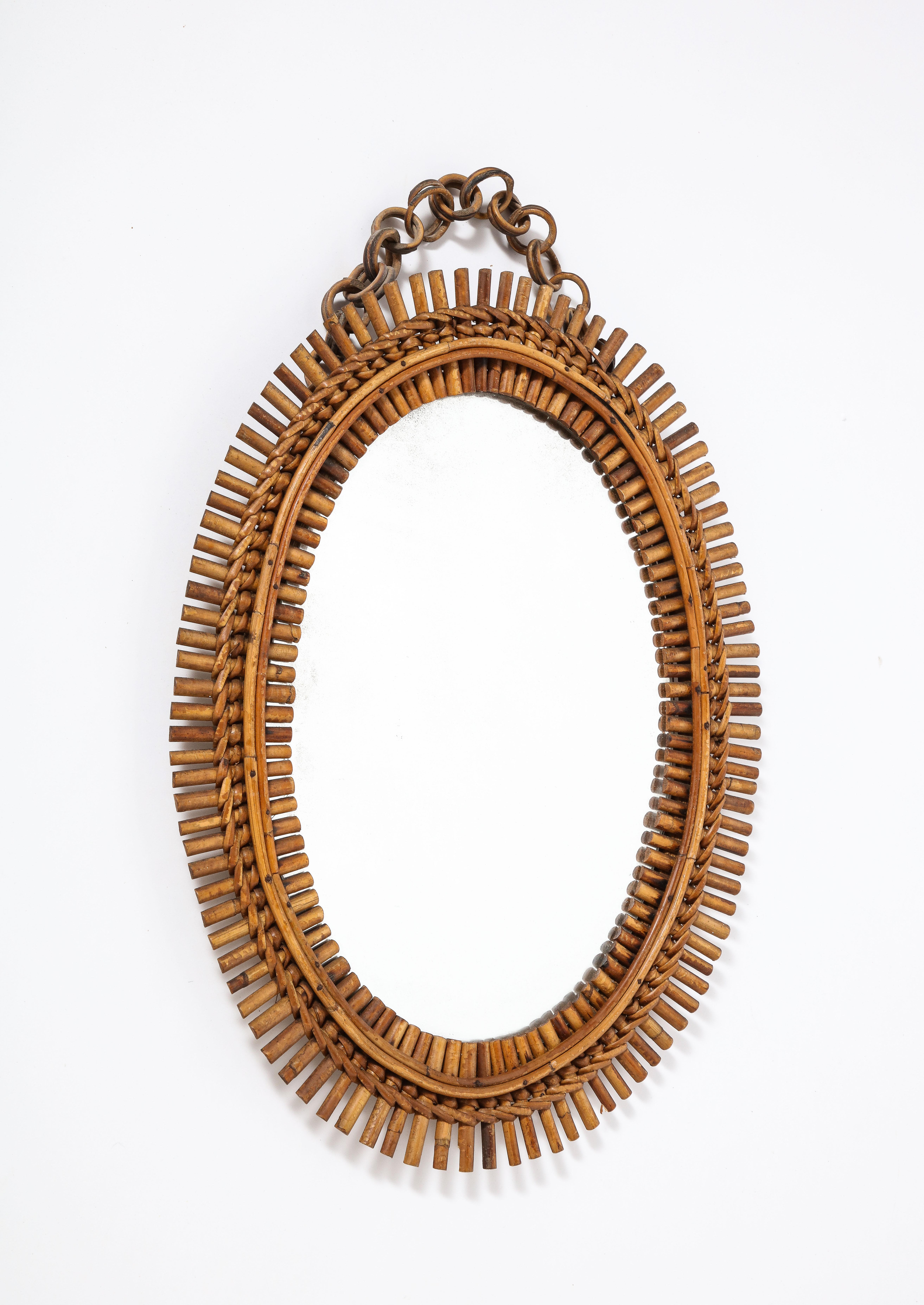 An Italian 1950's oval bamboo mirror with charming chain. Original velvet backing and mirror plate. 
Italy, circa 1950 
Size: 27