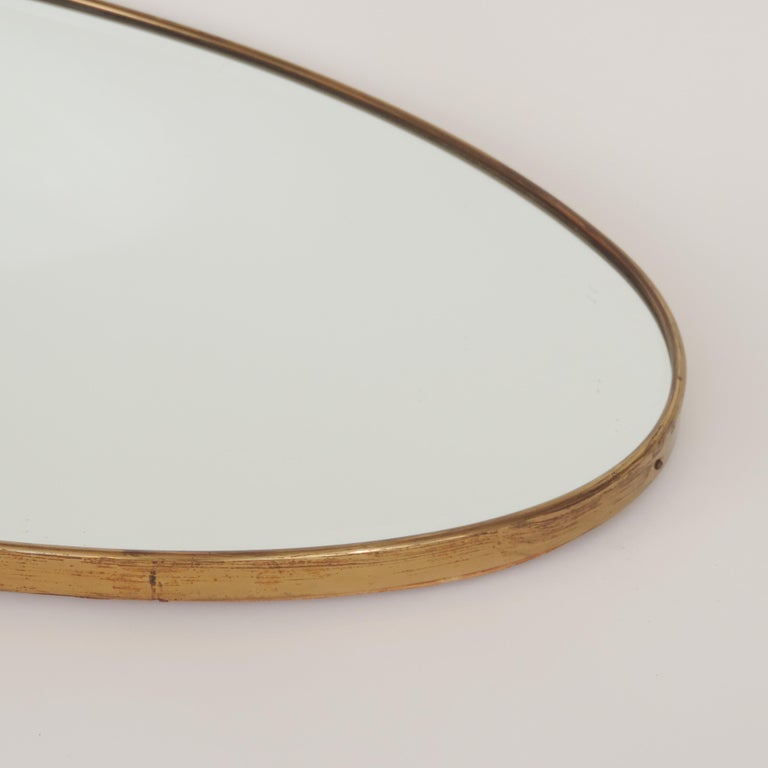 Italian 1950s oval brass framed glass mirror.
