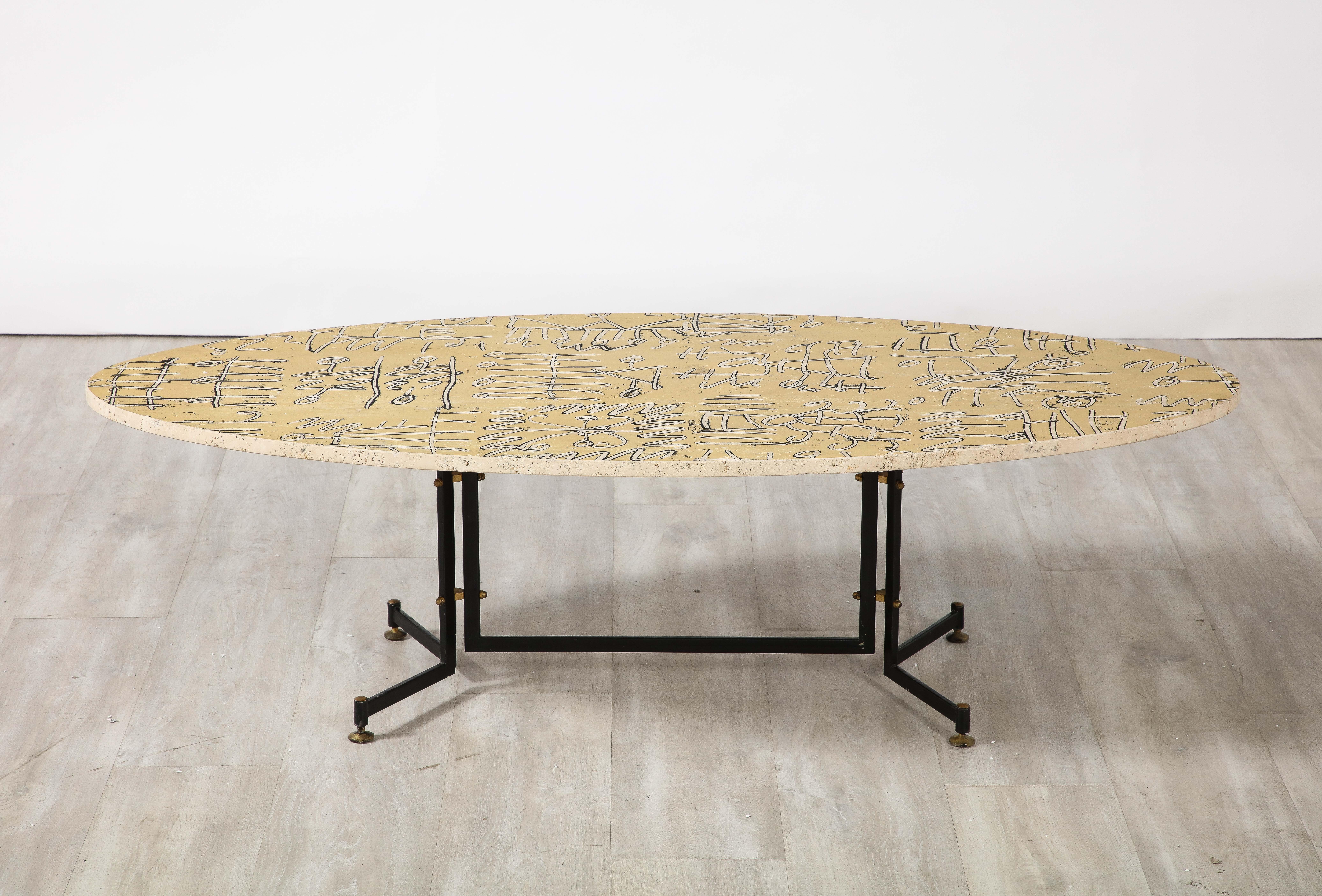 Italian 1950's coffee table, the oval travertine top is supported by a black enameled-steel base with charming brass accents. A highly unique piece, the surface of the travertine is painted with 'graffiti' style etchings. A truly one of a kind
