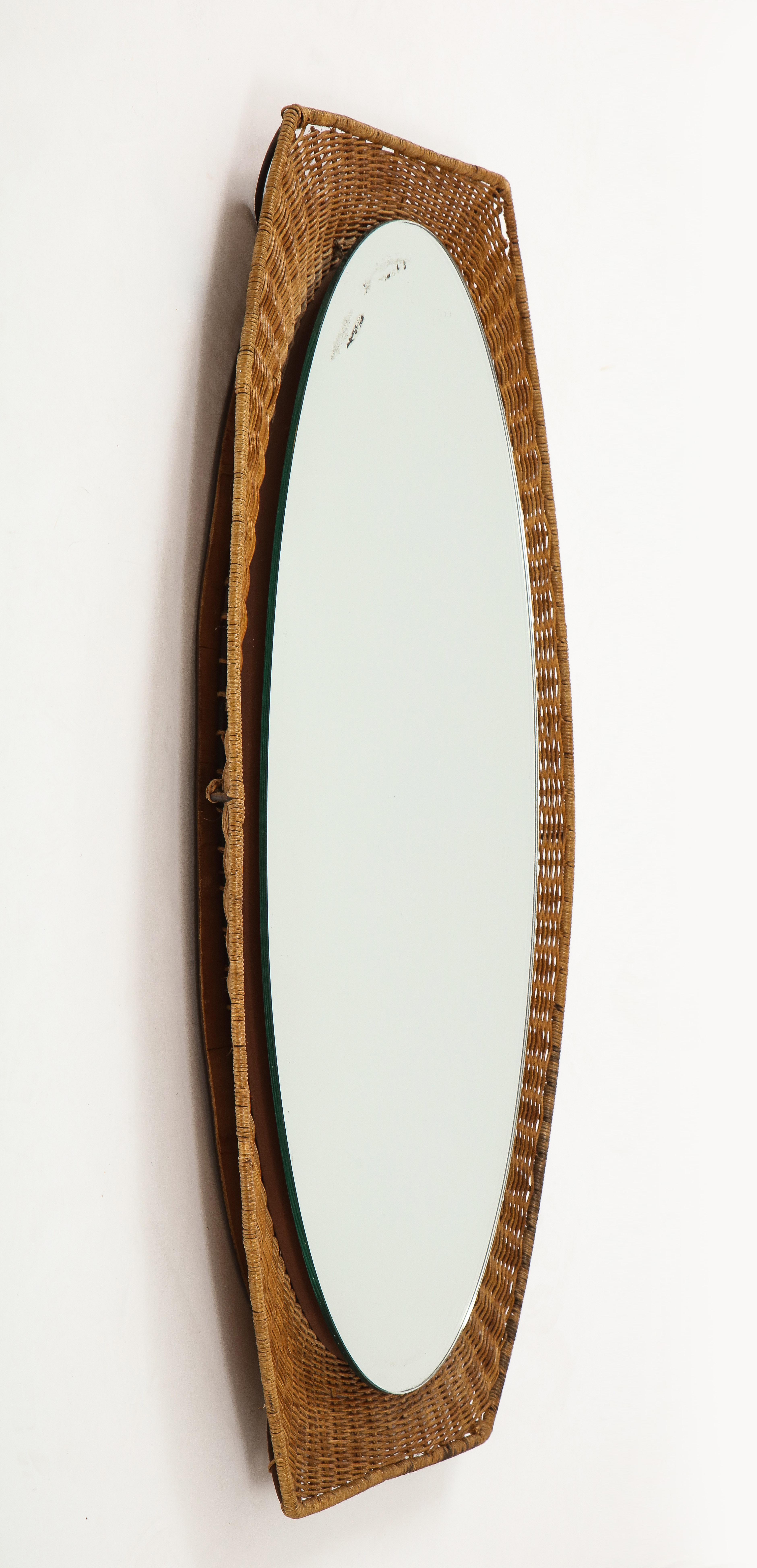 An Italian 1950s oval shaped mirror with shapely wicker surround. Elegant and organic vintage piece; original mirror glass.
Italy, circa 1950
Size: 35