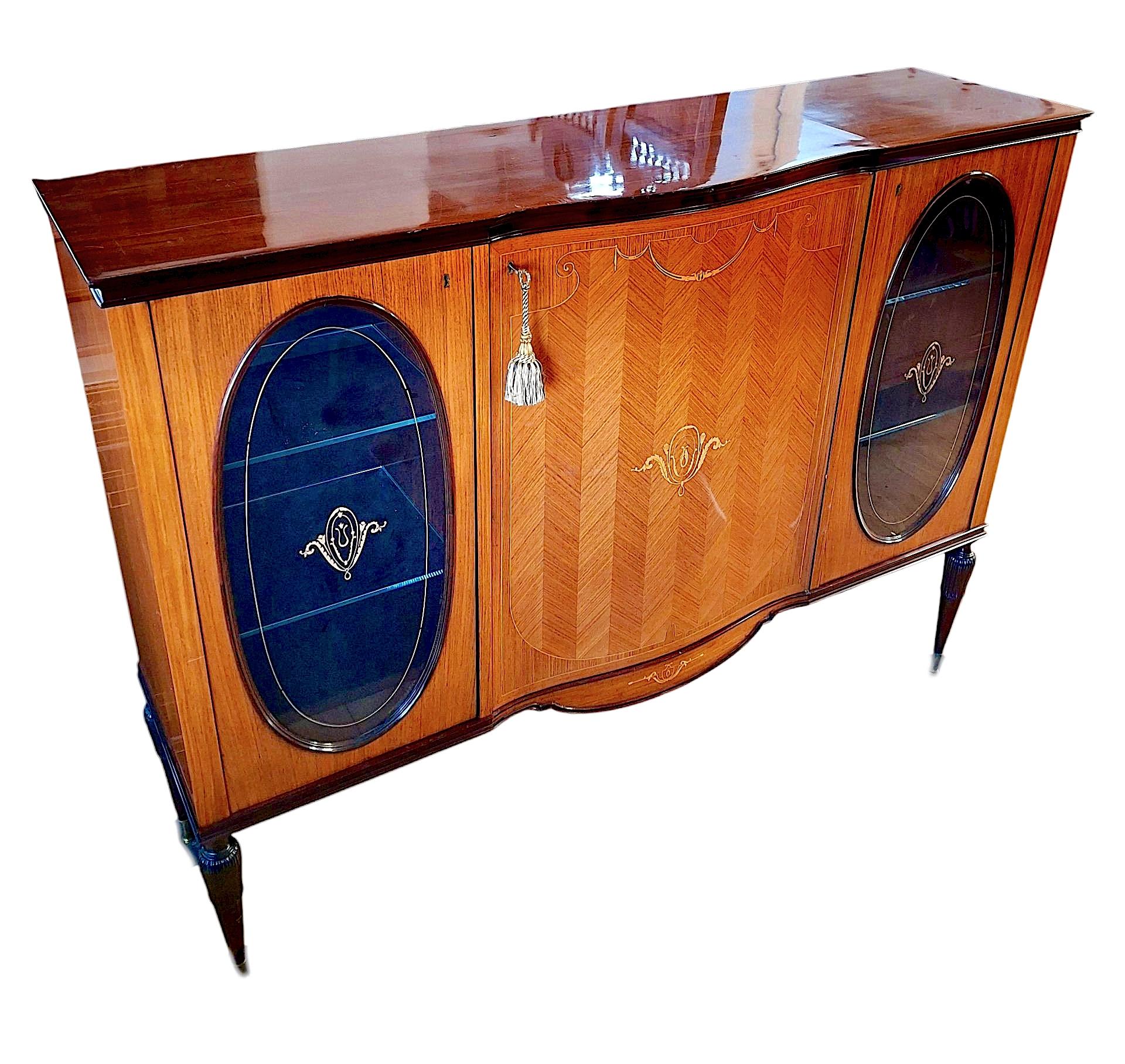 Beautiful Italian midcentury sideboard/bar cabinet attributed to Paolo Buffa. Two end cabinets with two glass shelves. Center cabinet with mirrored walls, glass shelf and two drawers. Tapered legs with brass feet. Maple veneer with French polish.

