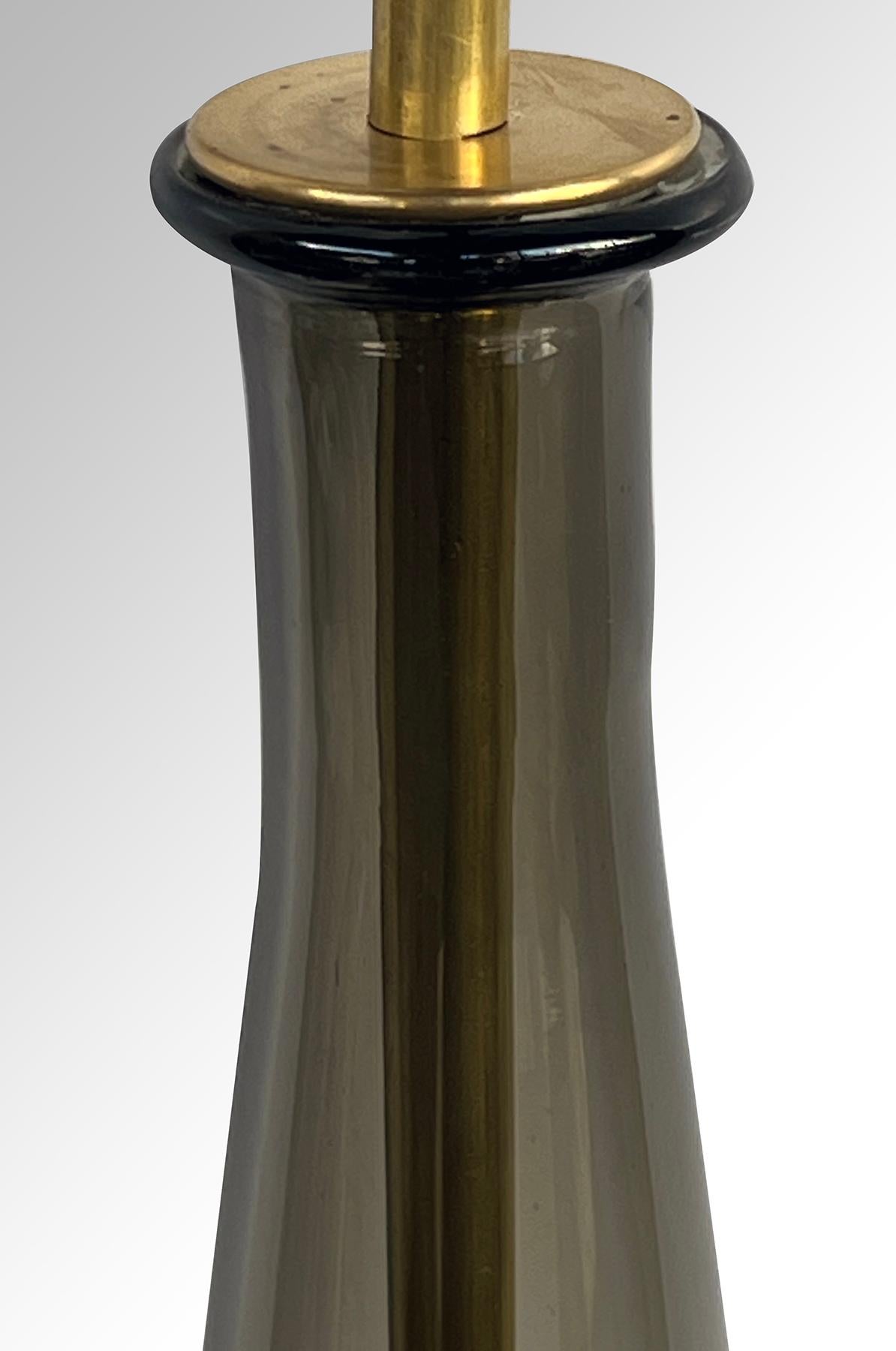 die hohe und auffällige gerippte Kunstglaslampe in konischer Form aus leuchtendem Rauchglas, die auf einem Messingsockel ruht; Empoli ist als das andere italienische Glas der Jahrhundertmitte bekannt. Einfacher im Design als ihre Cousins aus Murano,