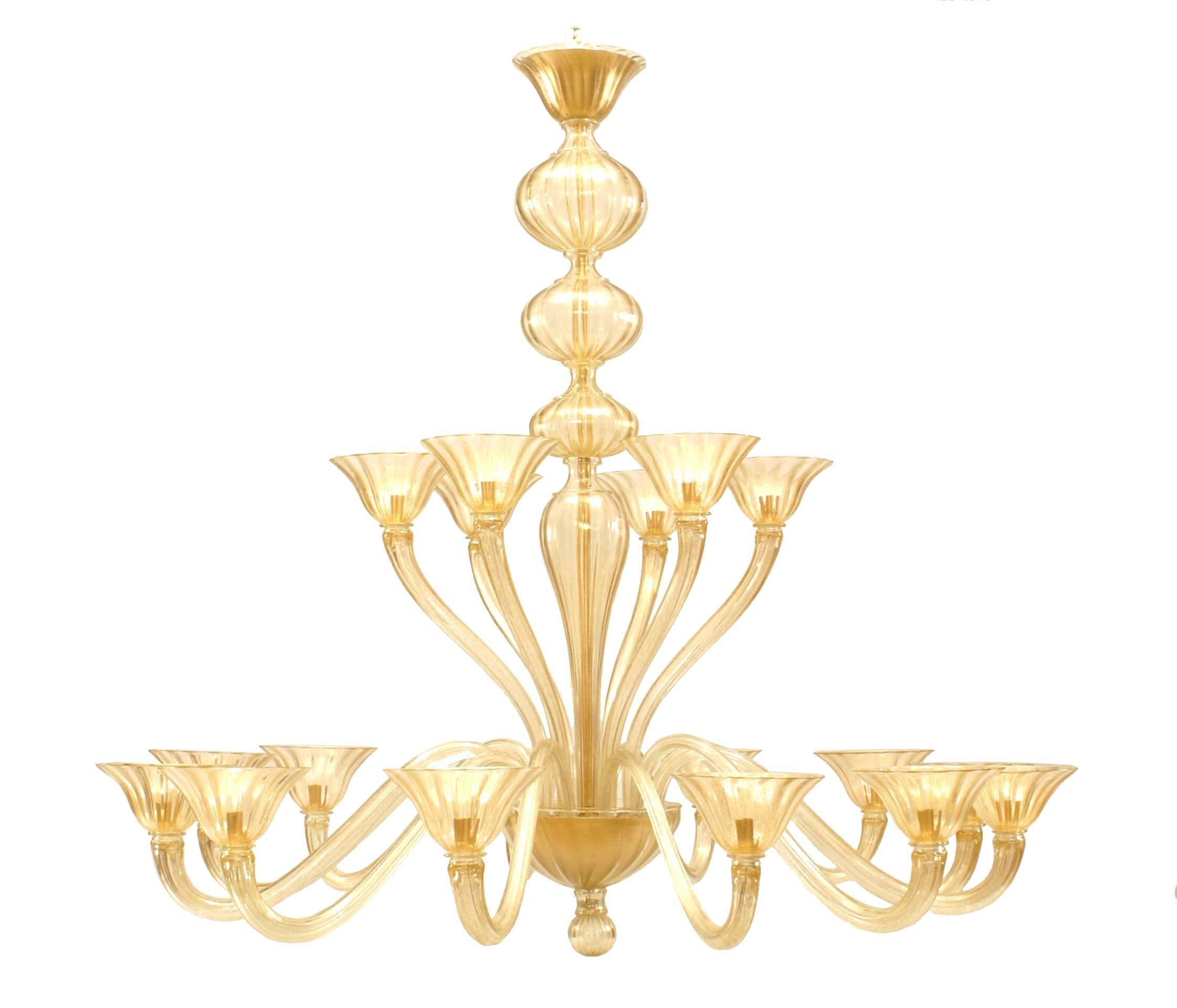 1950's style chandelier by Seguso composed of fluted gold dusted glass with eighteen s-shaped arms holding cup shades, divided between two tiers, one with six arms and the other with twelve.