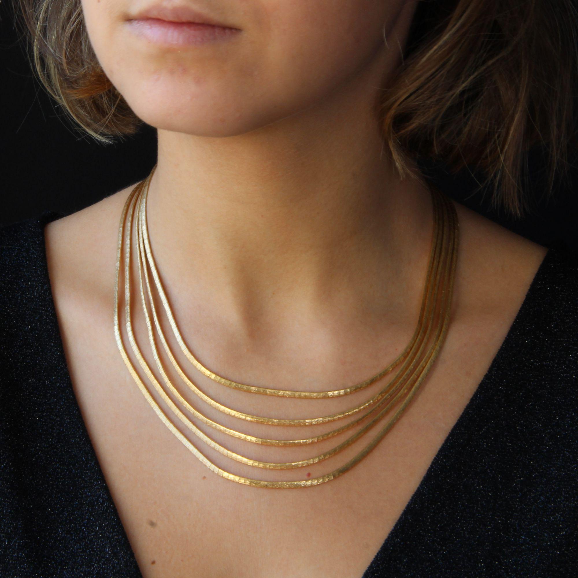 Necklace in 18 karat yellow gold.
Beautiful retro gold necklace, it is formed of 5 rows of omega mesh in fall and held by a large gold clasp with ratchet and safety 