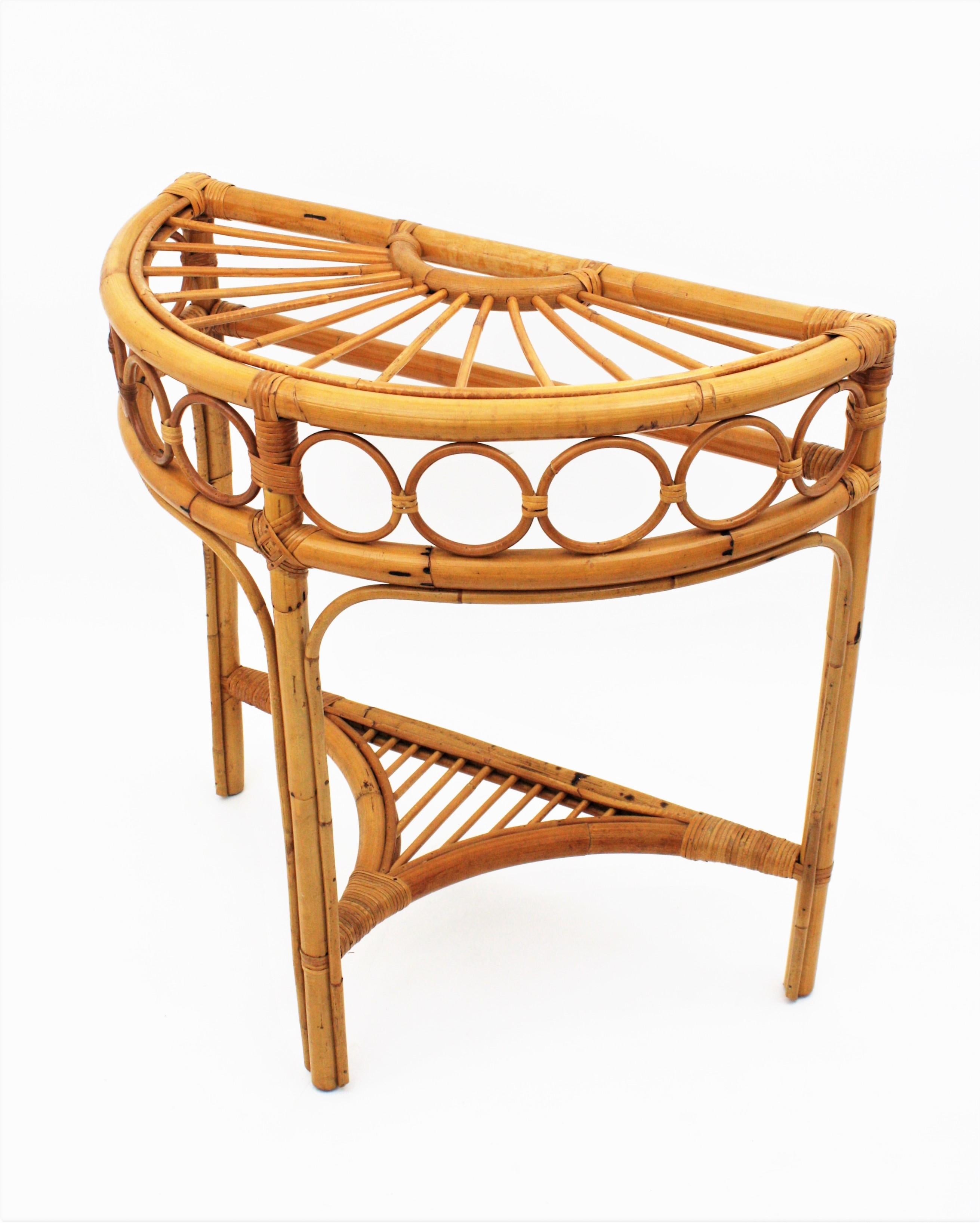 Eye-catching bamboo and rattan arched console table with rising sun top. In the style of Franco Albini. Italy, 1960s.
This console table stands up on three bamboo legs joined between them by a stretcher/shelf. The top features a rattan rising sun