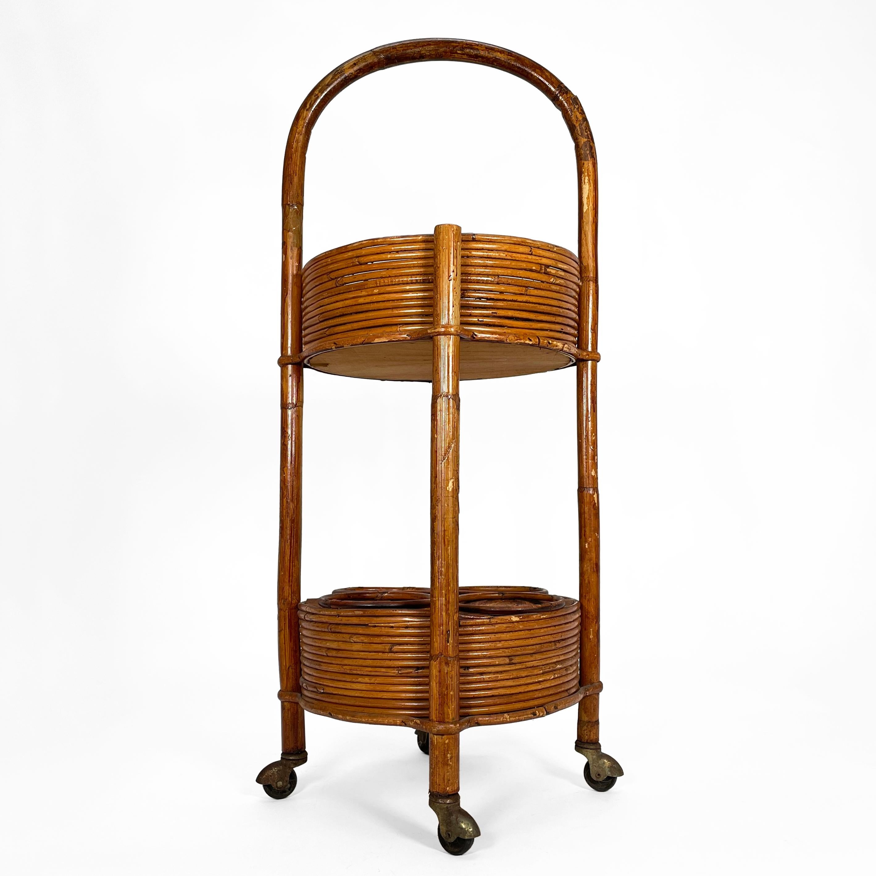 Charming italian bar cart from the 1960s in lovely vintage condition. 
The bar trolley impresses with its combination of bamboo and rattan and is lined with red velvet fabric on both levels. The lower level can safely store up to four bottles, while