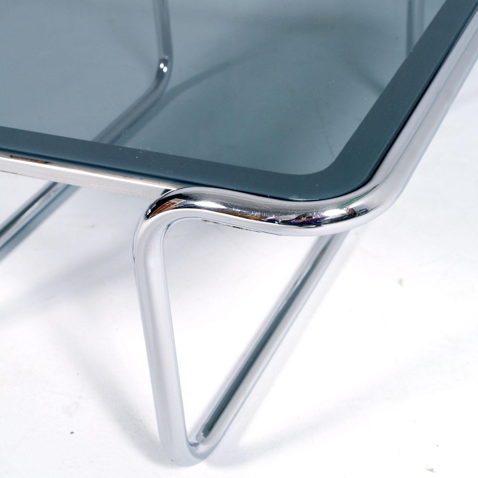 Tavolo da cocktail tubolare in vetro e cromo di design Giotto Stoppino.
Con bordi incisi
Misure cm: H. 35, L. 80, P. 80.