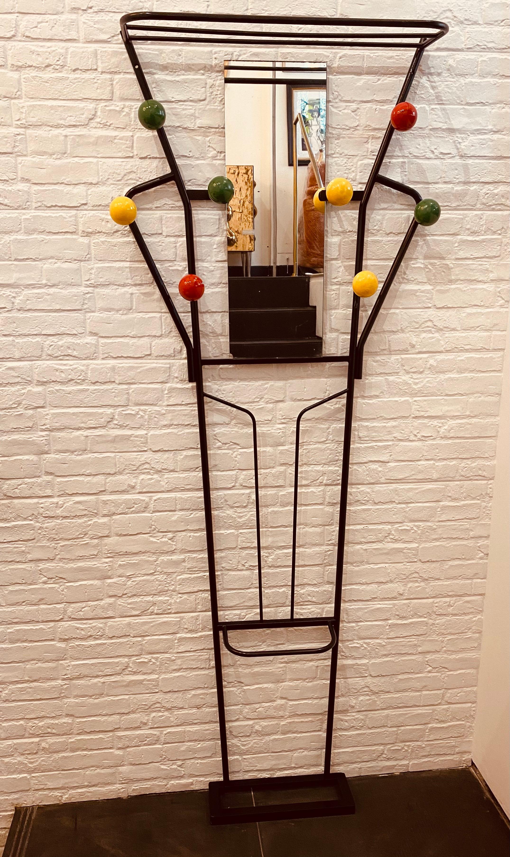 A vintage freestanding coat, luggage, and umbrella stand in black lacquered metal with 8 alternate colour wooden spheres and a rectangular center mirror. 

Dimensions: H:173 cm, W:67 cm, shelf depth:21 cm