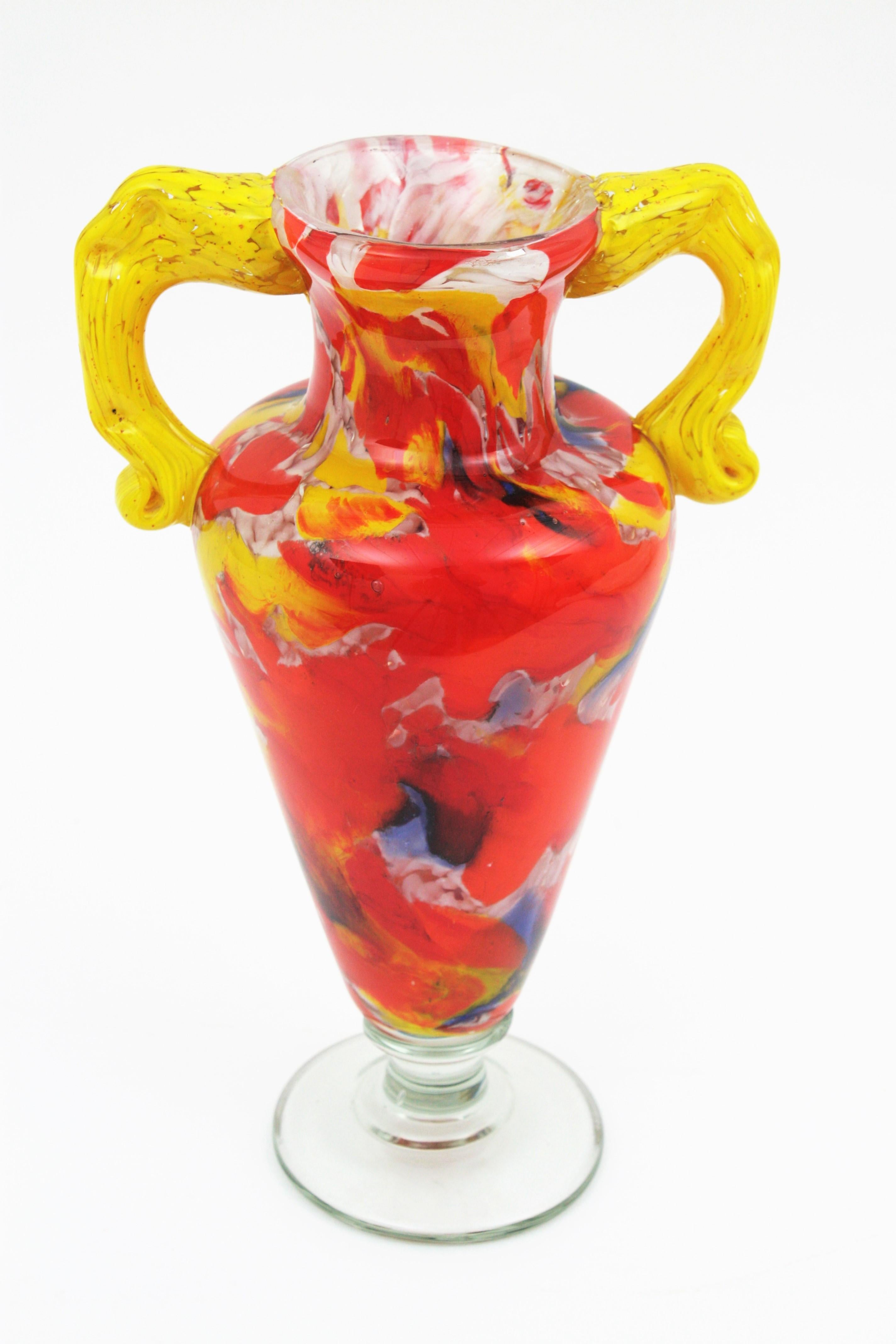 Amazing hand blown Murano glass vase with a colorful murrine glass decoration. A highly decorative piece in a vibrant red color, yellow handles and blue, orange and white accents, Italy, 1960s.

 