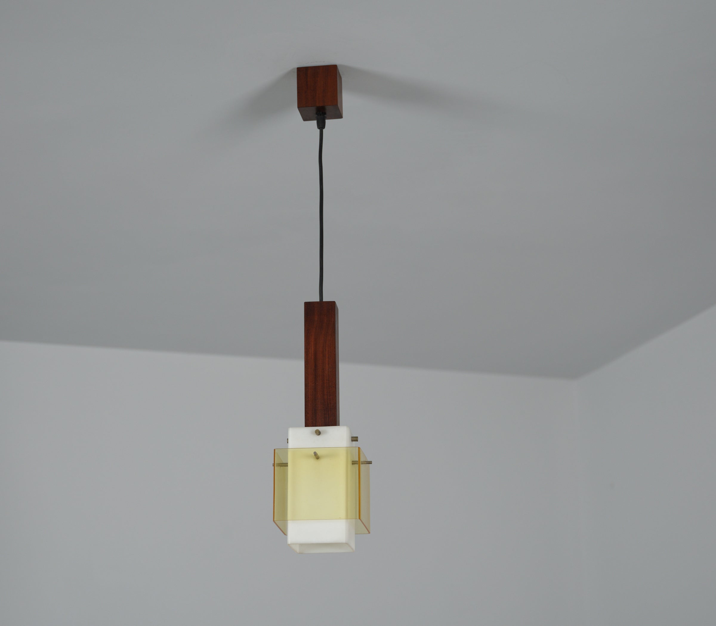 Presenting an Italian pendant lamp hailing from the 1960s. Crafted with a profound appreciation for design and quality, this lamp features a rich, dark teak wooden structure. The centerpiece of this pendant is the milk perspex shade, casting a warm