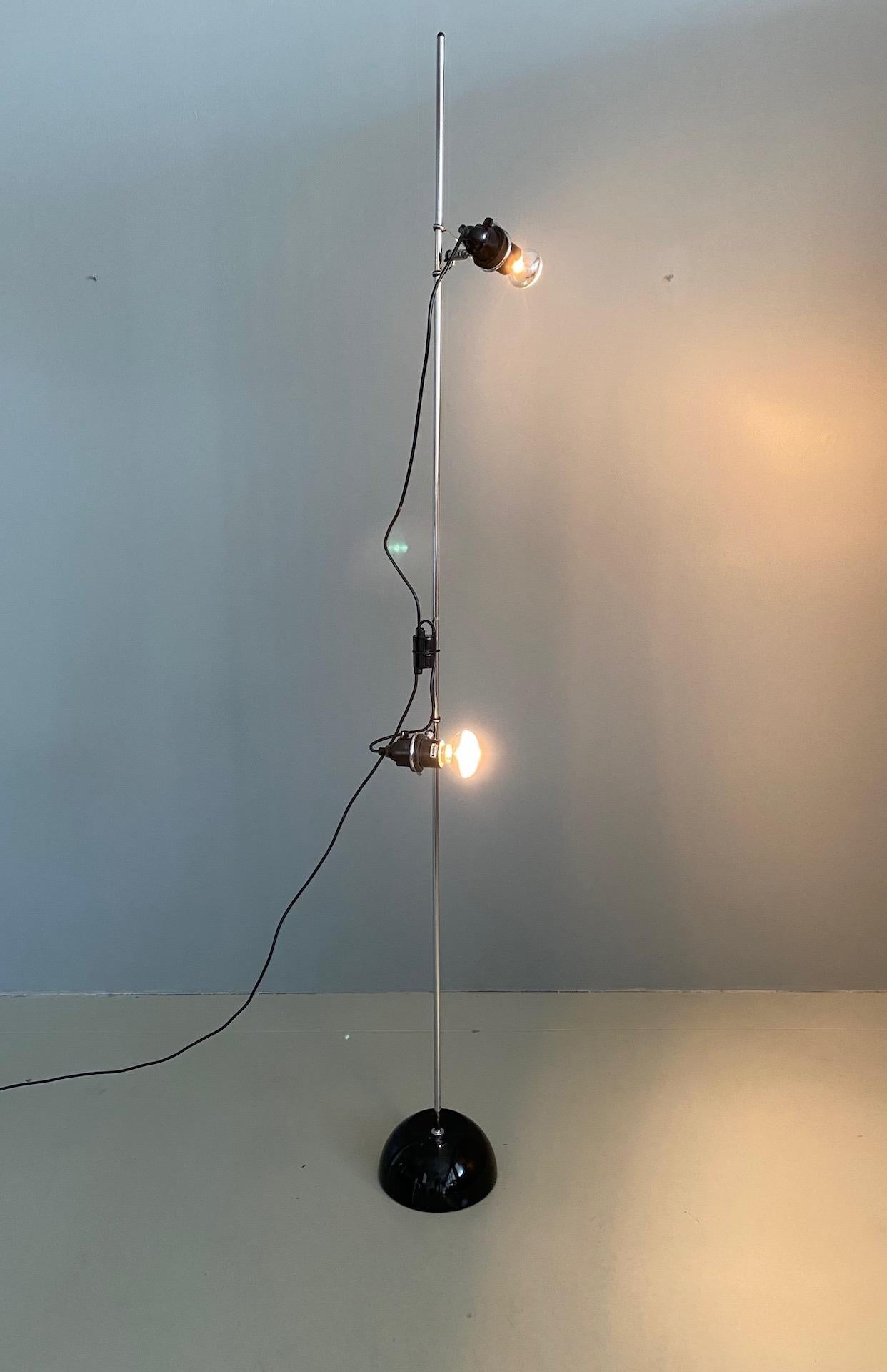 Fantastic Italian floor lamp by Harvey Guzzini 2 multi positional bulb holders, switched individually, can be angled in any position and can be moved up and down the central stem which drops into a heavy lacquered black base.