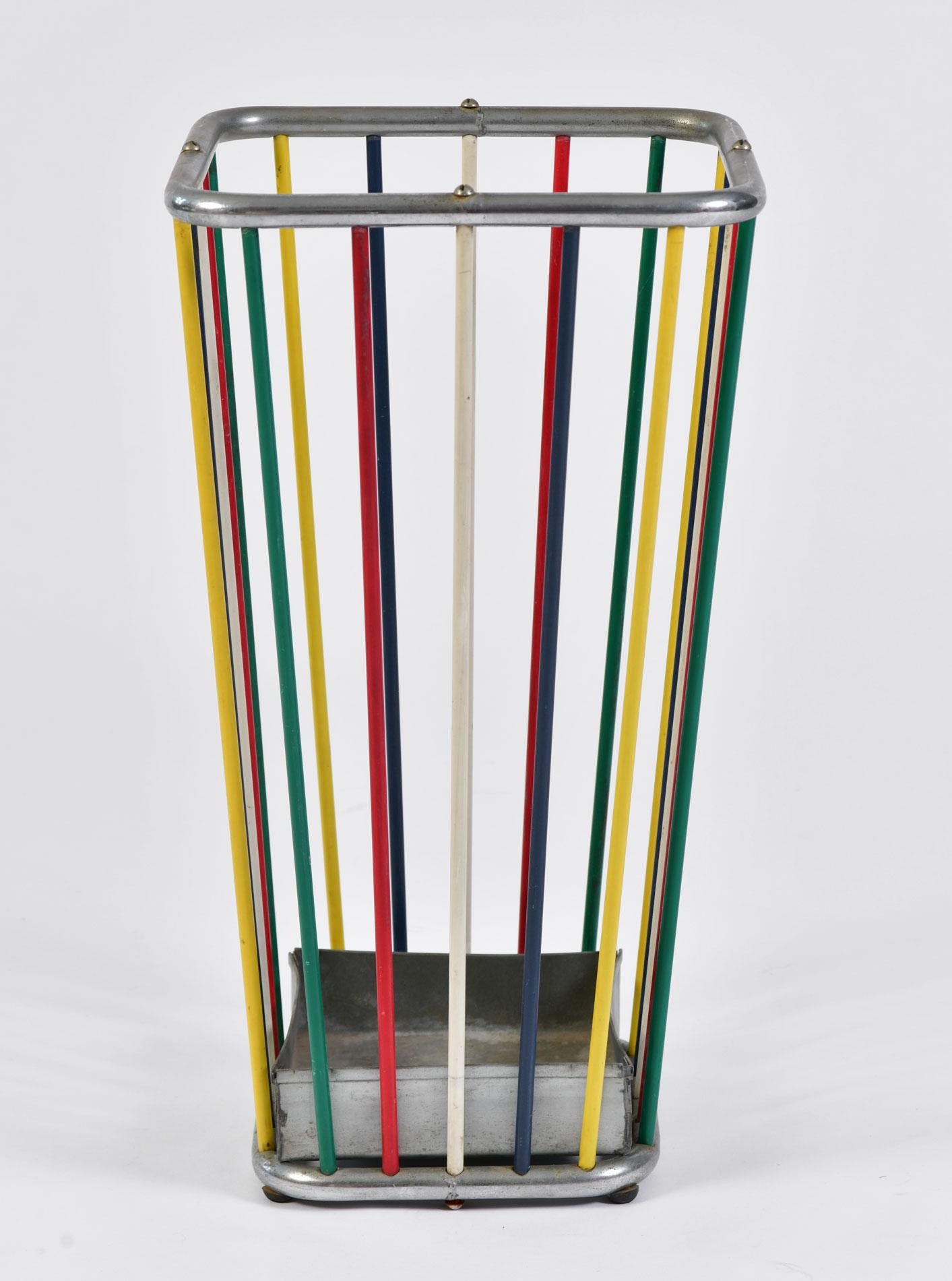 Bold chrome framed umbrella stand decorated with green, red, white blue and yellow coated metal bars. Removable base tray.