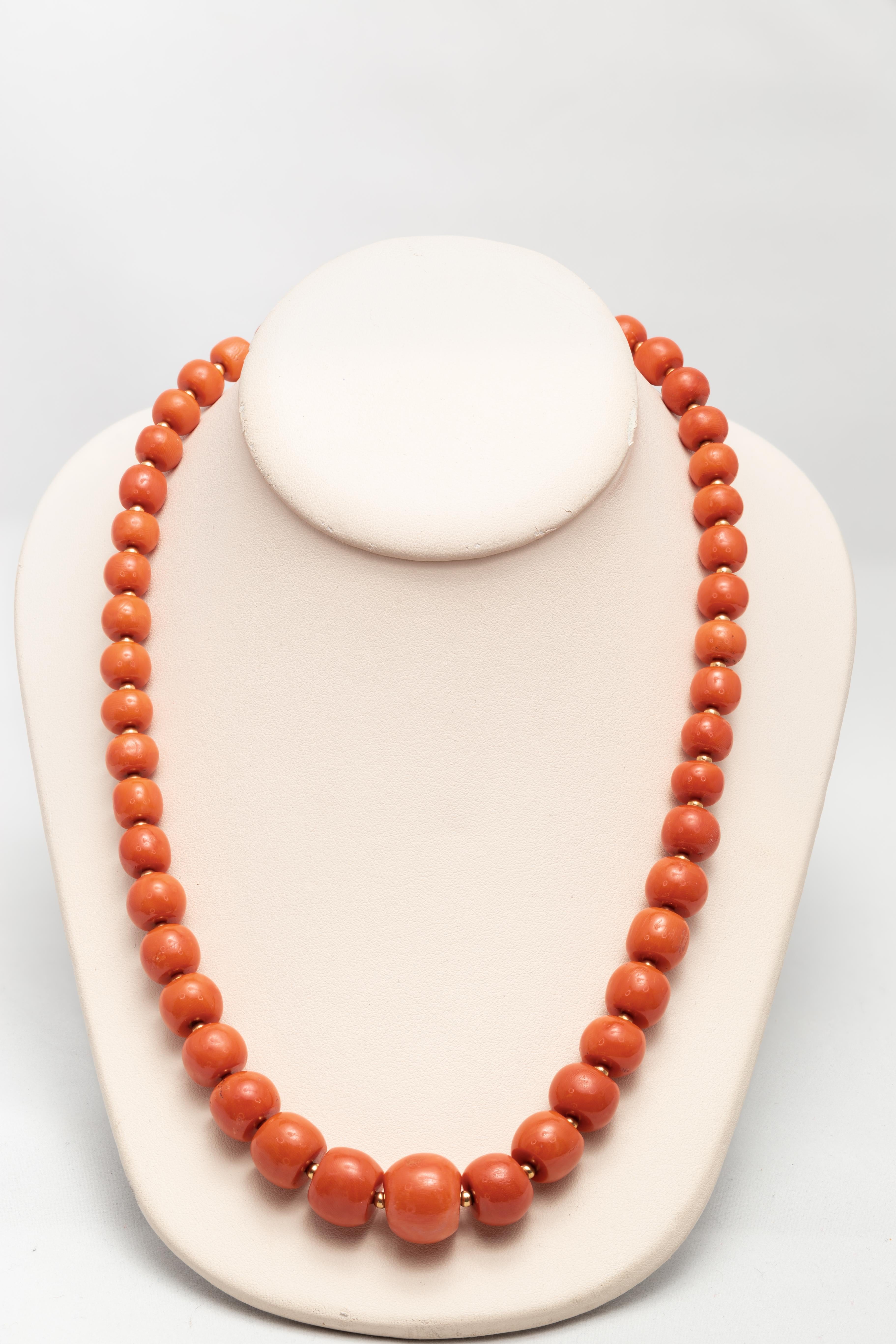 A Modern Italian coral beaded necklace in 18K yellow gold mount, circa 1960. Capturing our attention with its natural and untreated coral beads ranging from 8 to 16 mm, this trendy necklace presents a hooked clasp with twisted accents. Created in