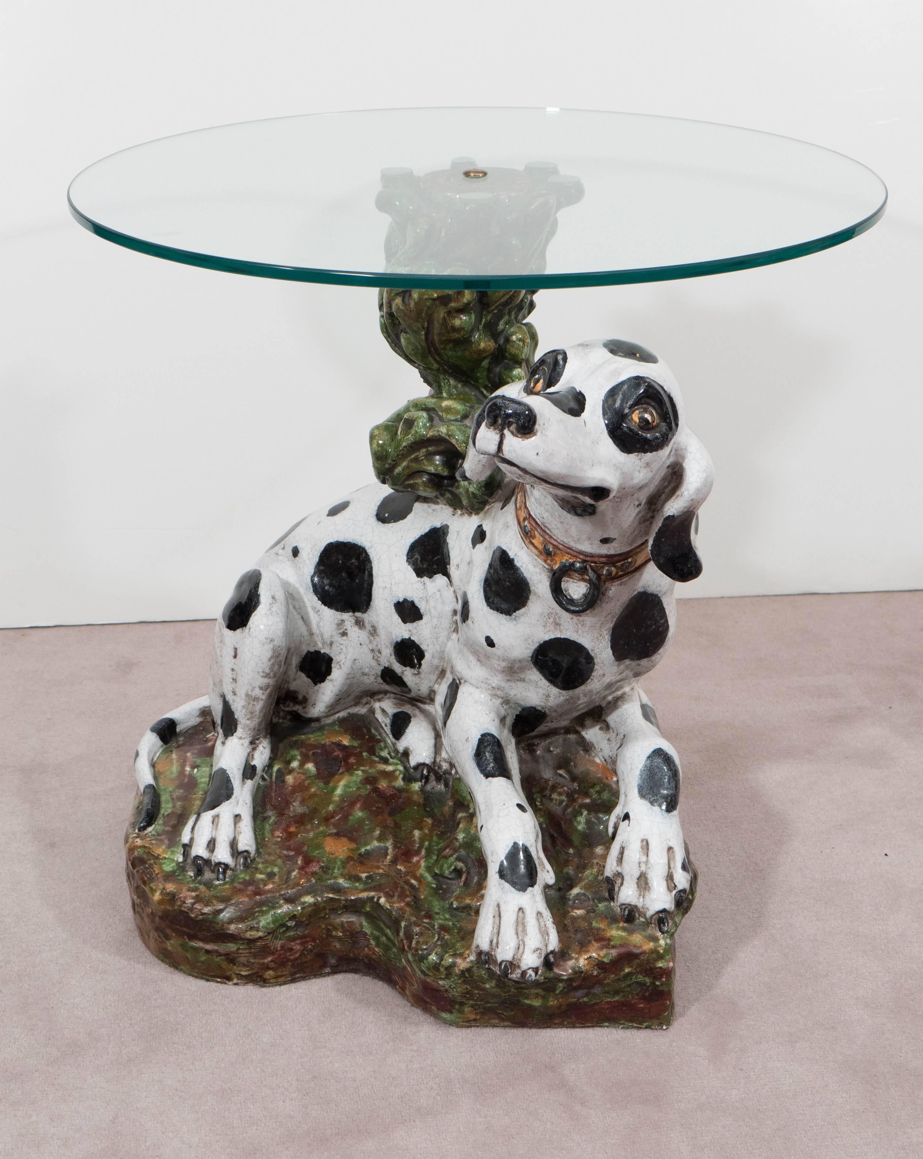 Occasional side table, produced in Italy circa 1960s, with round glass top, supported by a hand painted, faux bois ceramic base, designed as a twisted branch with leafy foliage, emerging from a mossy patch of earth, including a sweet dalmatian dog,