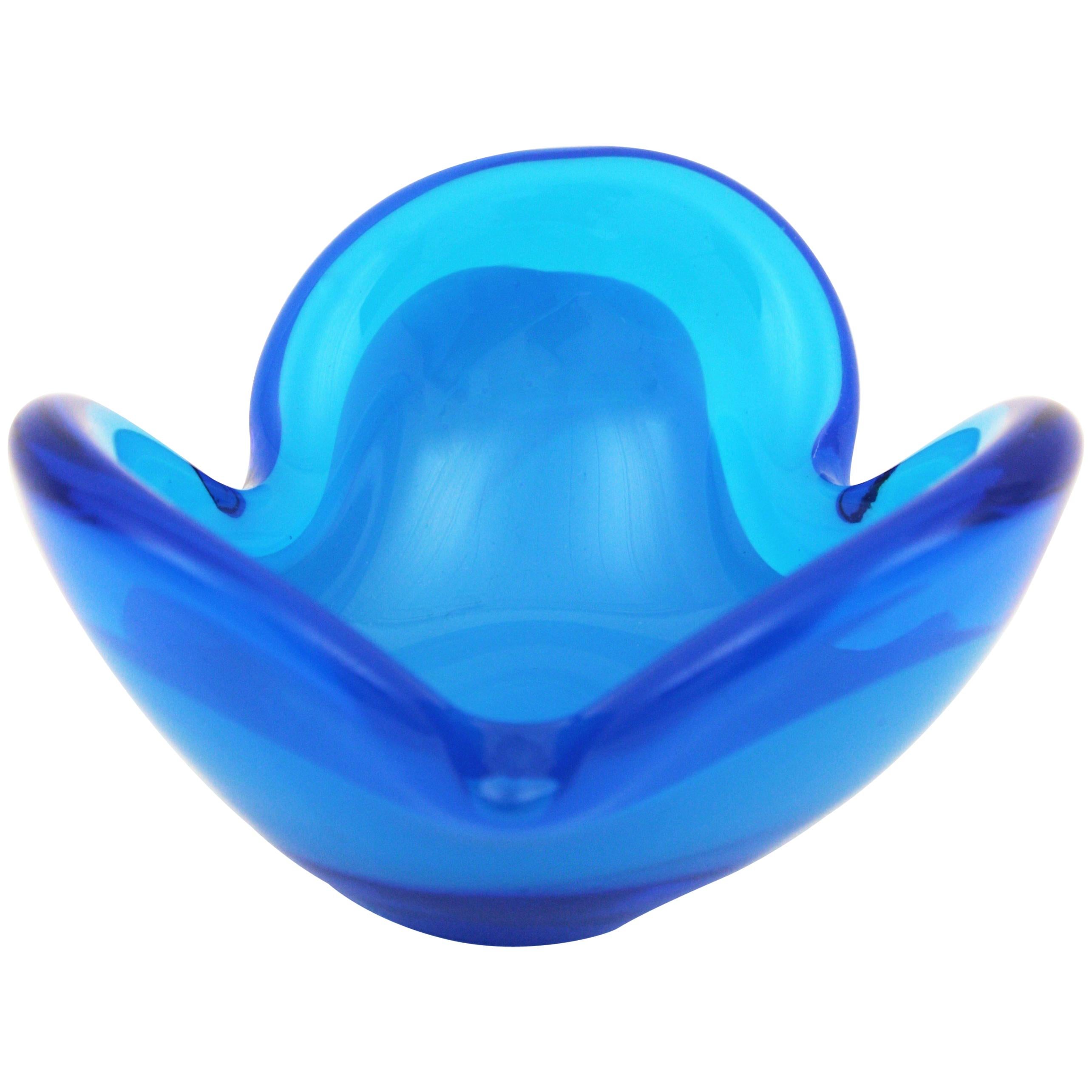 Lovely hand blown flower shaped Murano glass bowl in Blue Klein color and opaline glass. Attributed to Seguso Italy, 1960s.
Opaline blue glass cased into clear klein blue glass with organic or flower shape design with some inner bubbles. Use it as